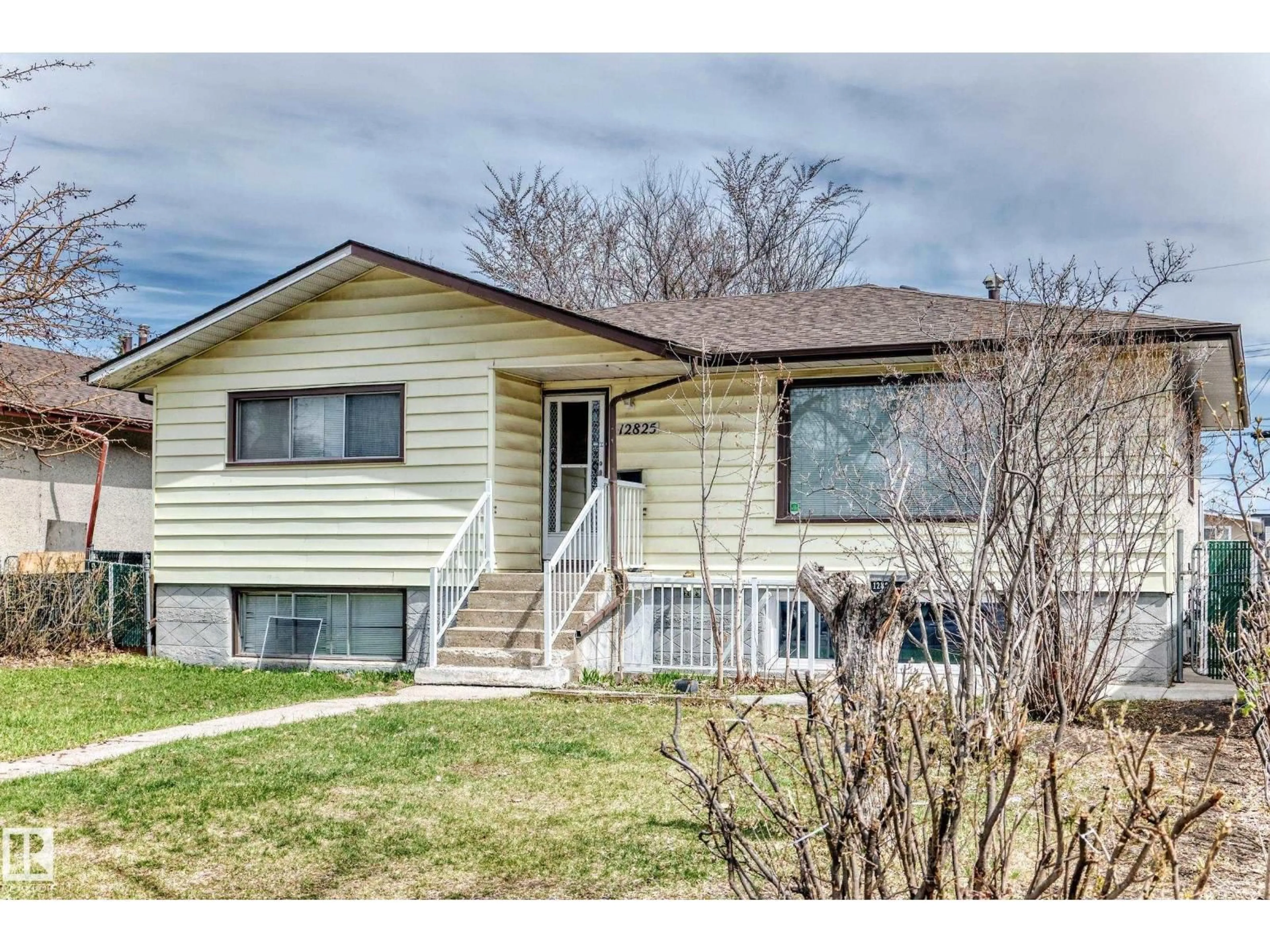 Home with vinyl exterior material, street for 12825 102 ST, Edmonton Alberta T5E4J2