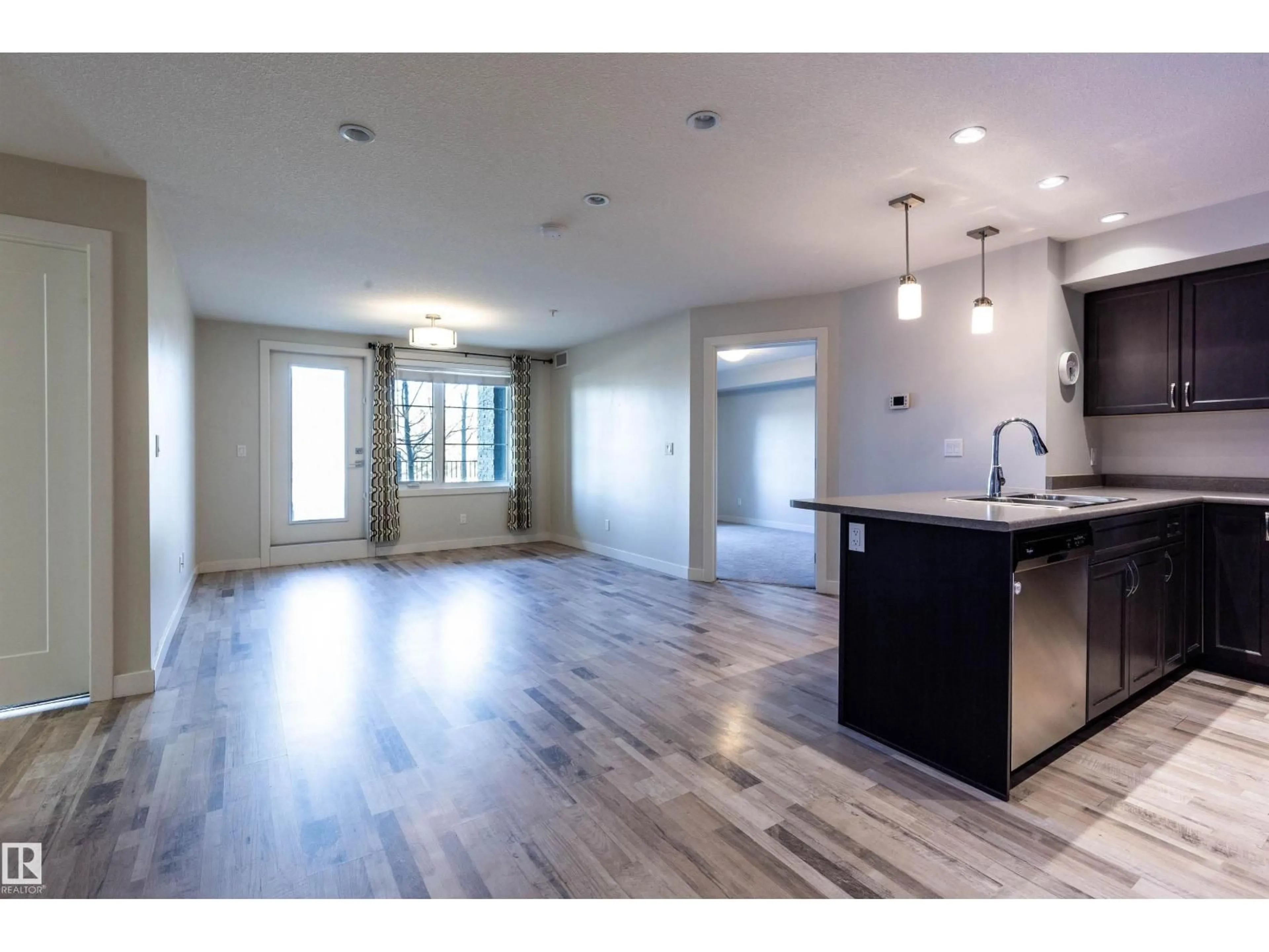 Open concept kitchen, wood/laminate floor for #109 - 5029 EDGEMONT BV, Edmonton Alberta T6M0S8