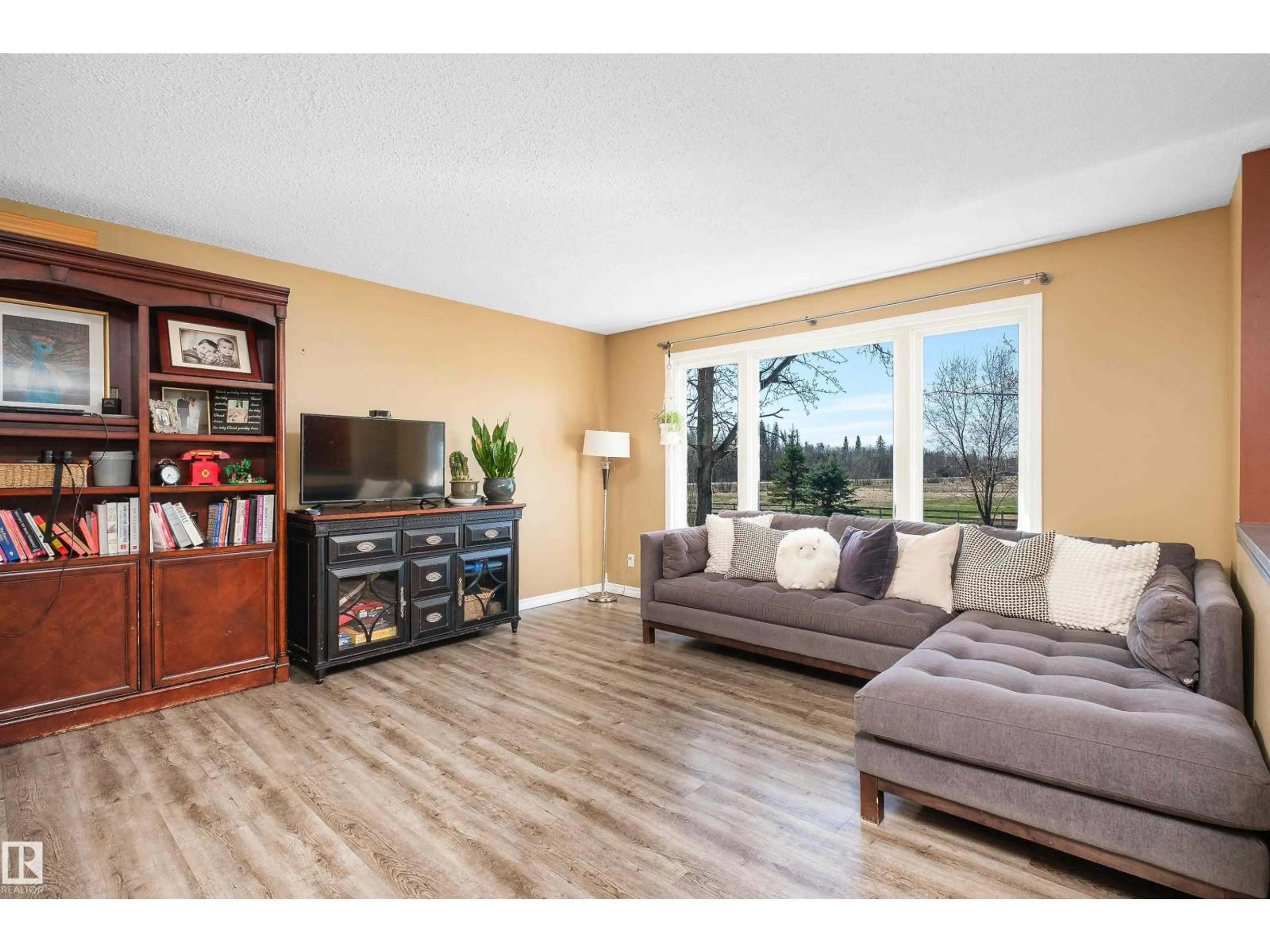 Living room with furniture, wood/laminate floor for 55416 HWY 765, Rural Lac Ste. Anne County Alberta T0E0L0
