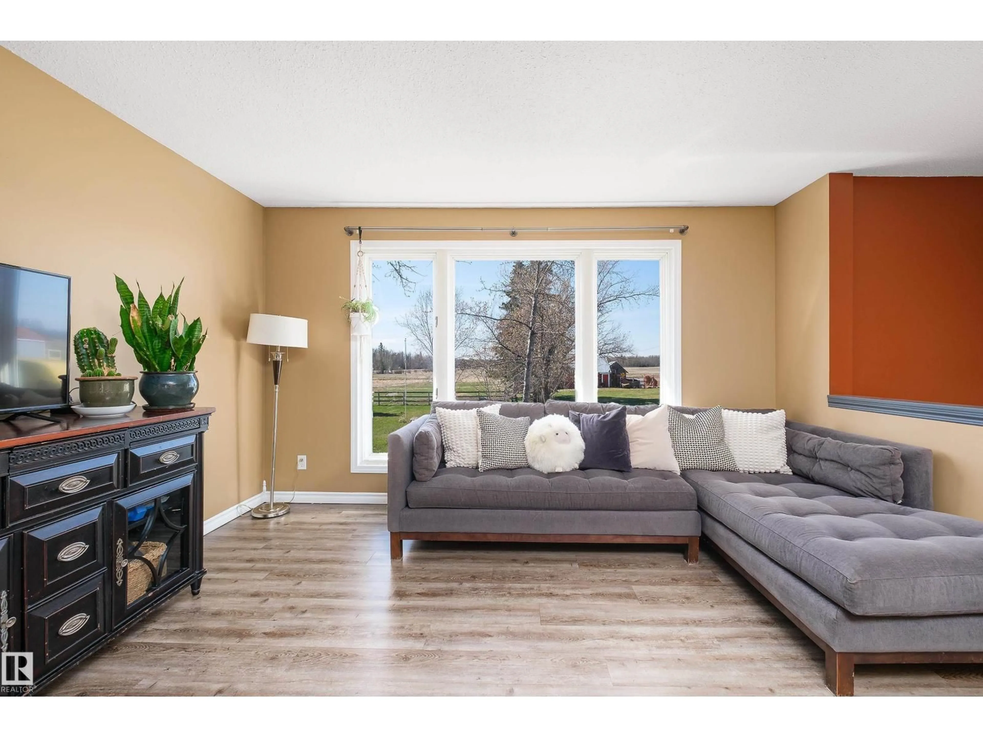 Living room with furniture, wood/laminate floor for 55416 HWY 765, Rural Lac Ste. Anne County Alberta T0E0L0