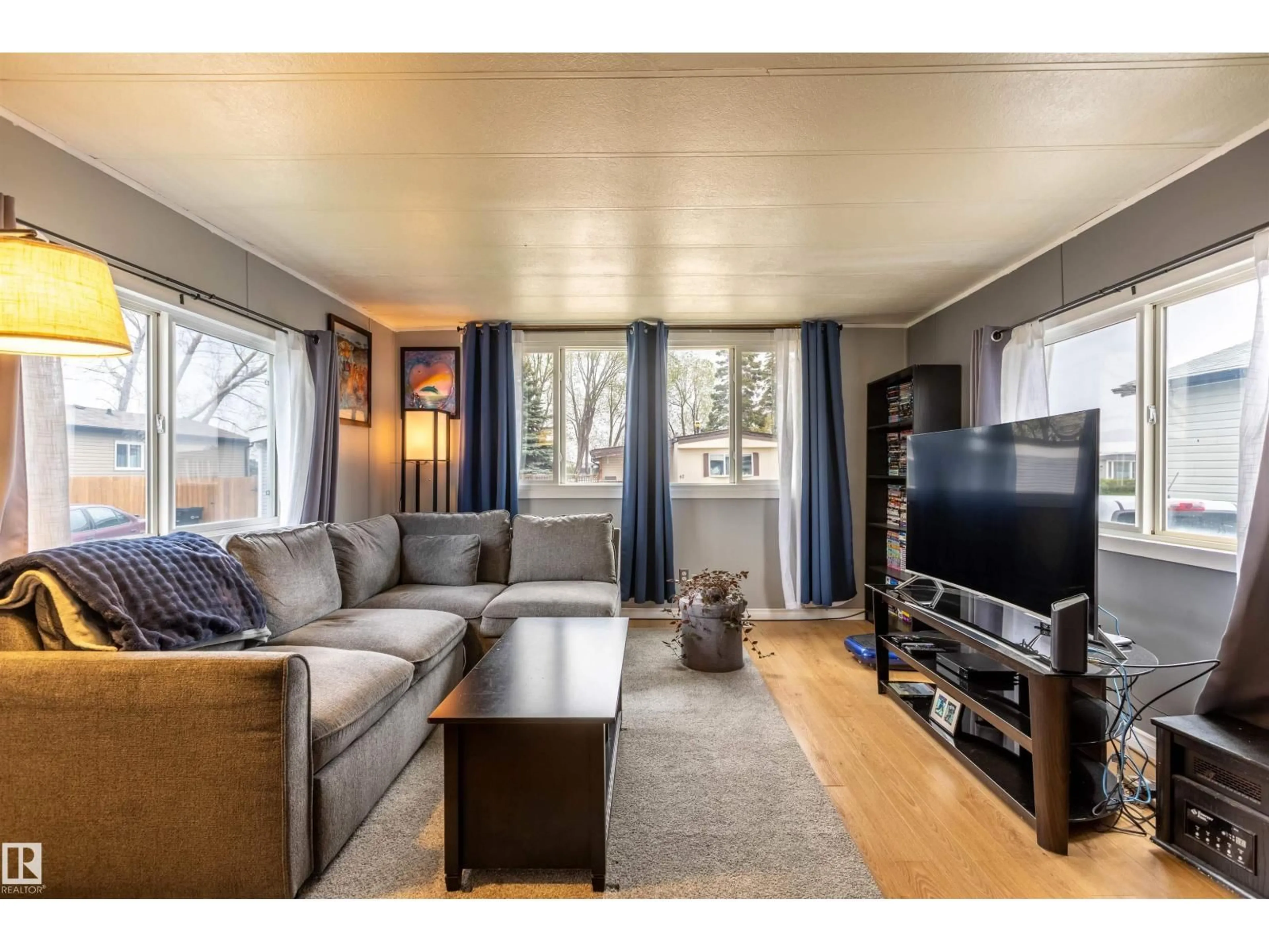 Living room with furniture, wood/laminate floor for 62 10401 101A ST, Morinville Alberta T8R1B2