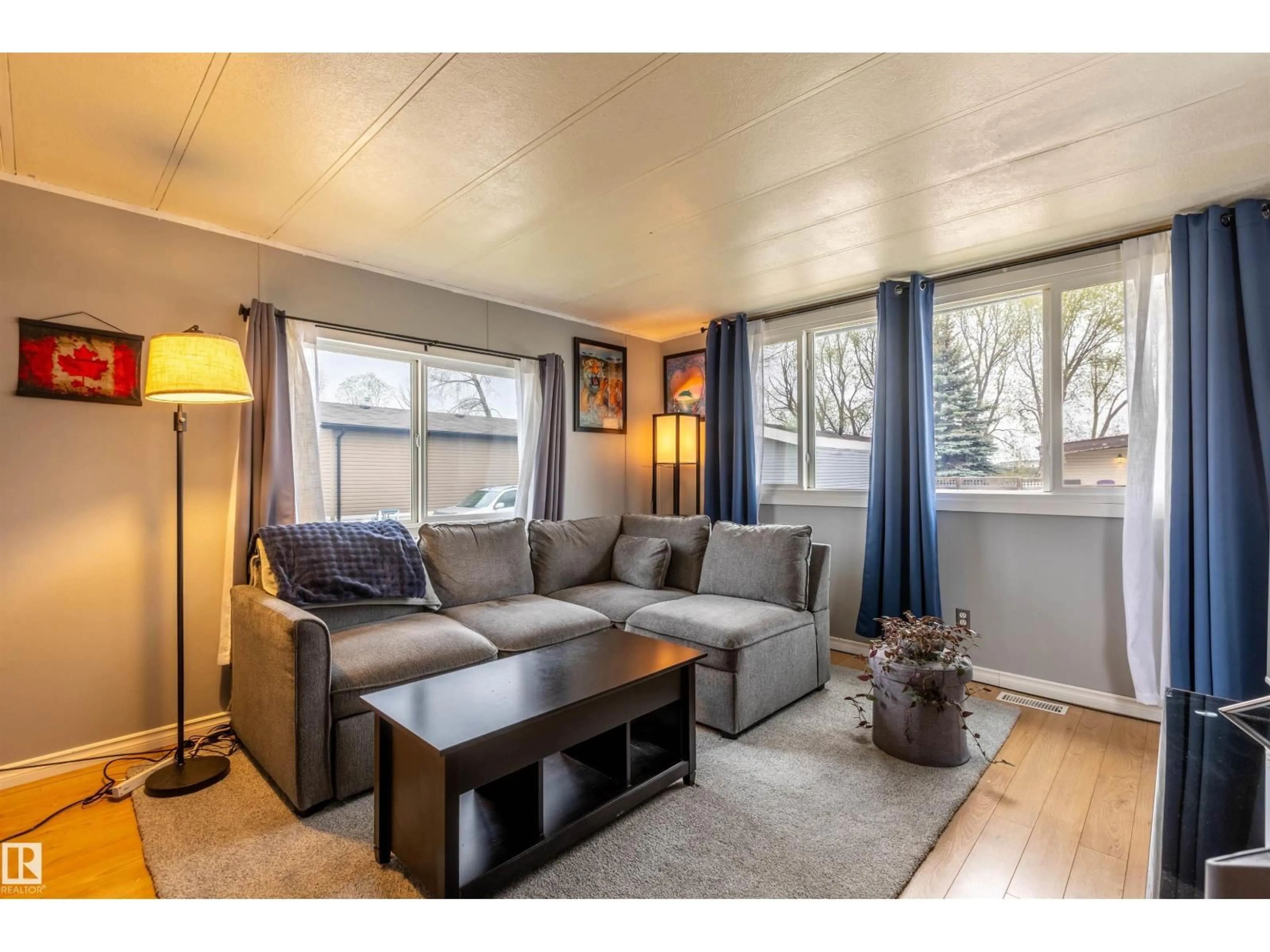 Living room with furniture, wood/laminate floor for 62 10401 101A ST, Morinville Alberta T8R1B2