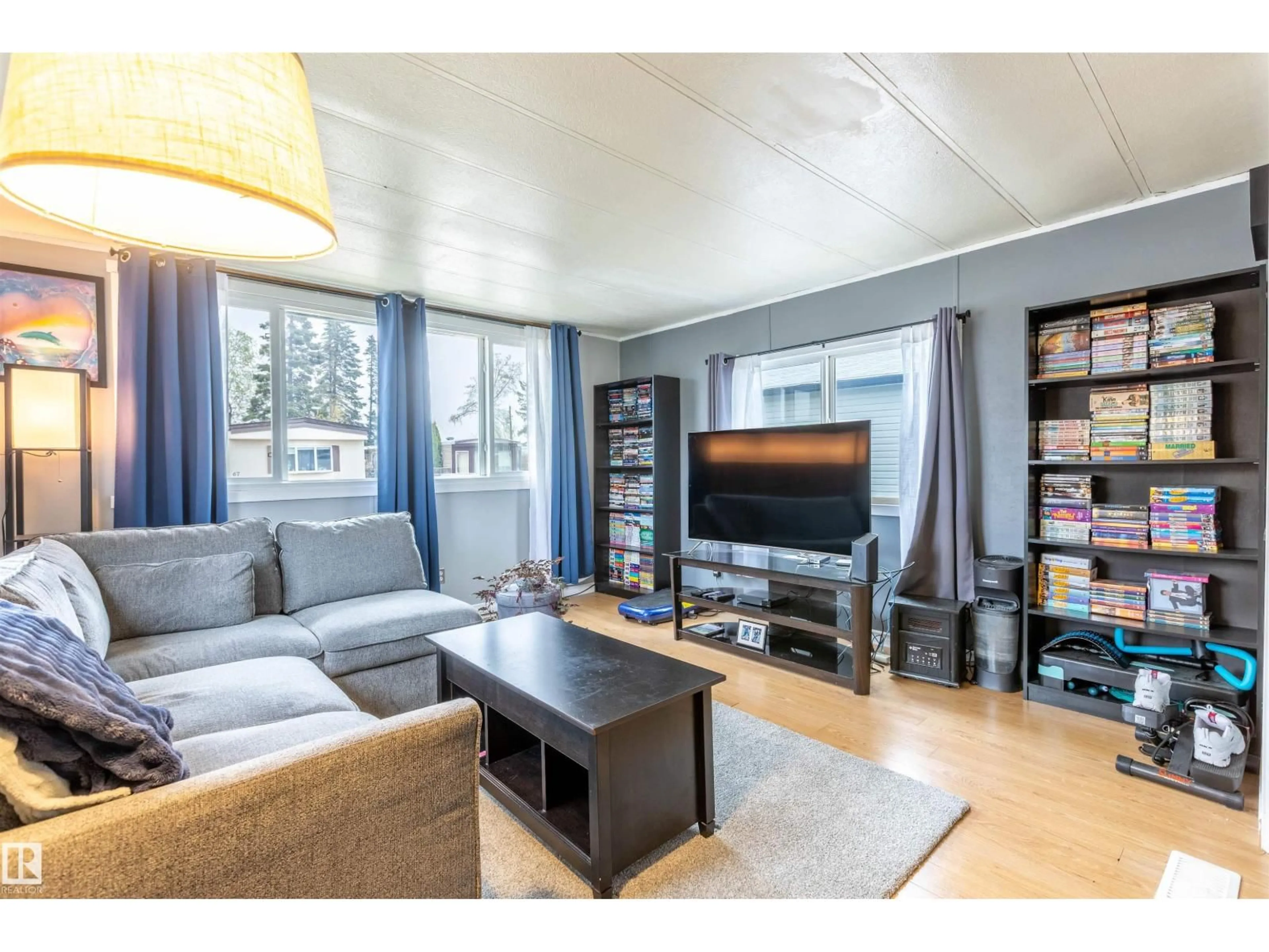 Living room with furniture, wood/laminate floor for 62 10401 101A ST, Morinville Alberta T8R1B2
