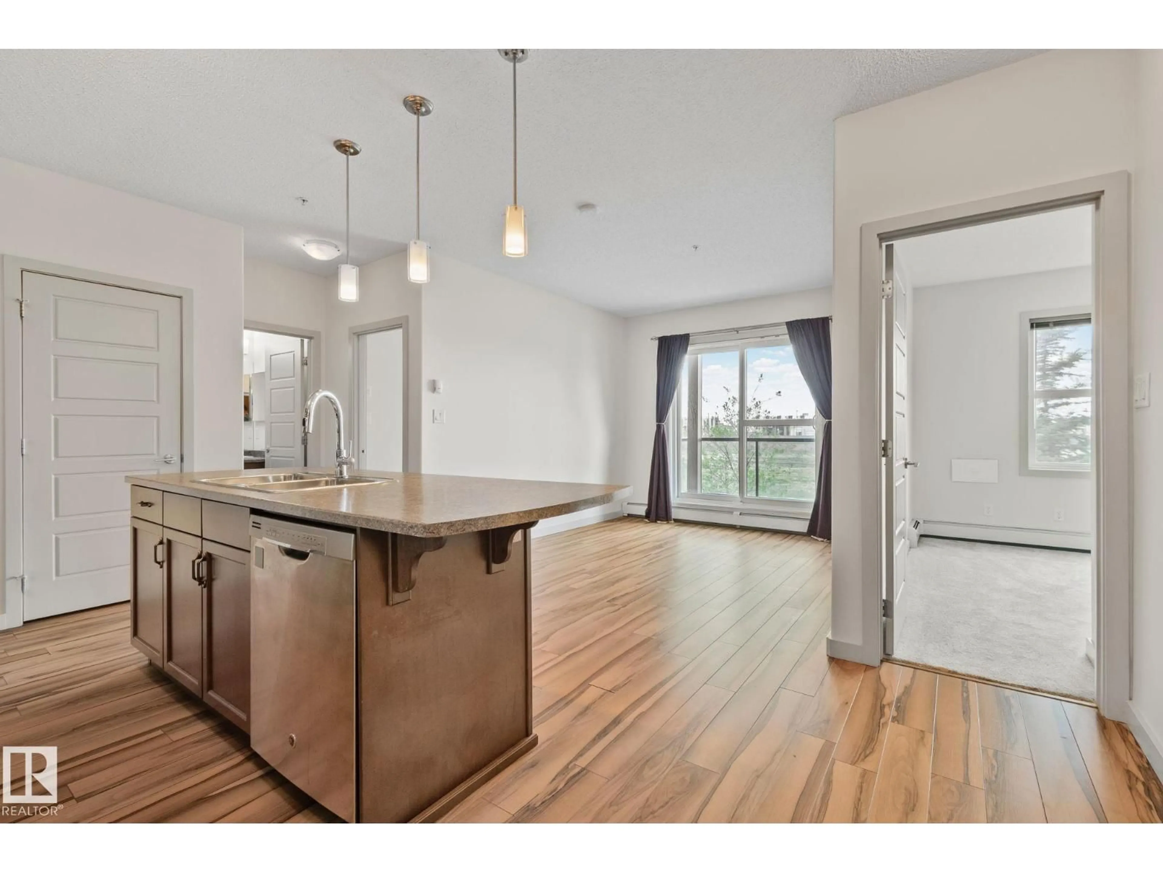 Open concept kitchen, wood/laminate floor for #218 - 320 AMBLESIDE LI, Edmonton Alberta T6W2Z9