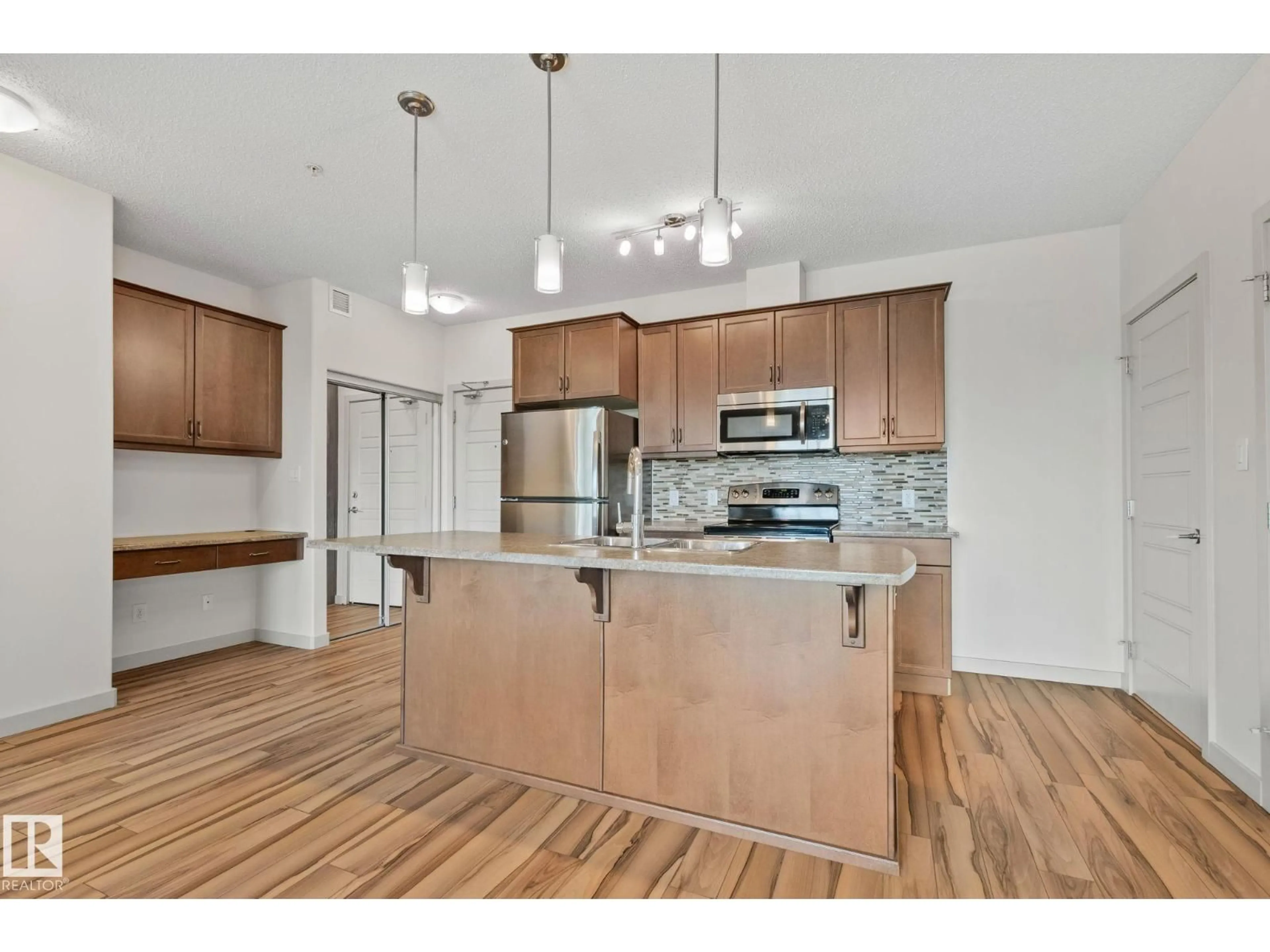 Open concept kitchen, wood/laminate floor for #218 - 320 AMBLESIDE LI, Edmonton Alberta T6W2Z9