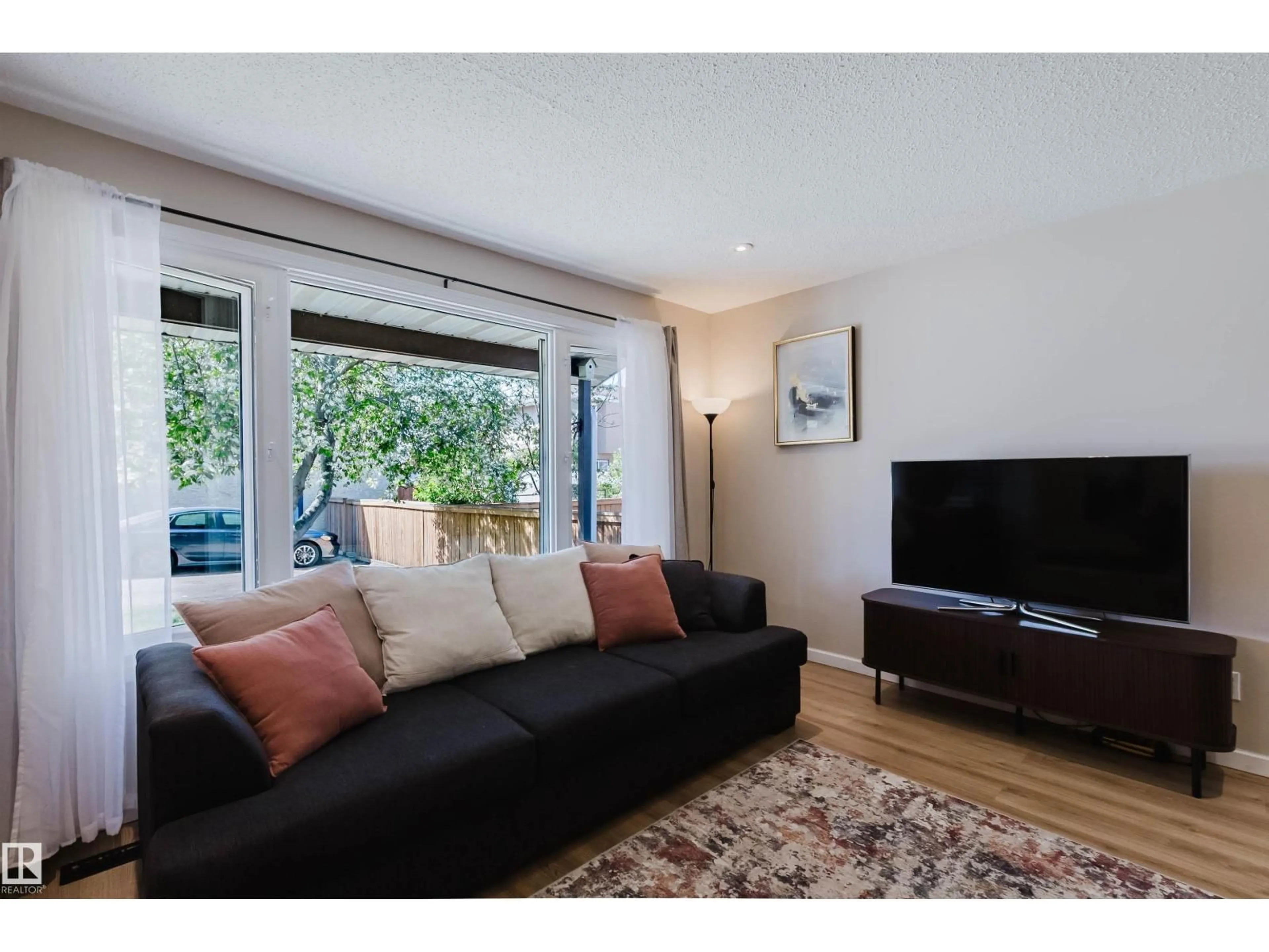 Living room with furniture, wood/laminate floor for 10946 BEAUMARIS RD, Edmonton Alberta T5X1Z6