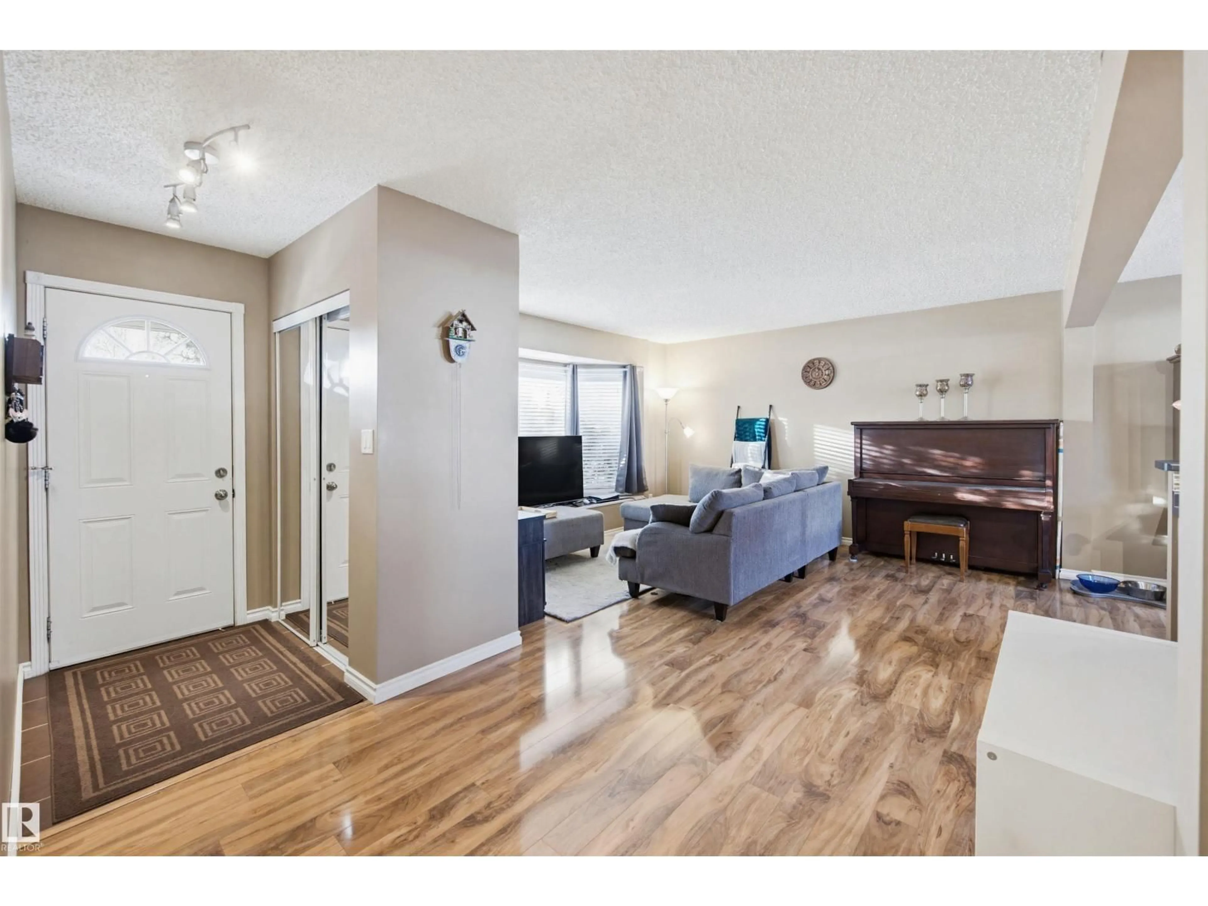 Living room with furniture, wood/laminate floor for NW - 3426 120 AV, Edmonton Alberta T5W1K2