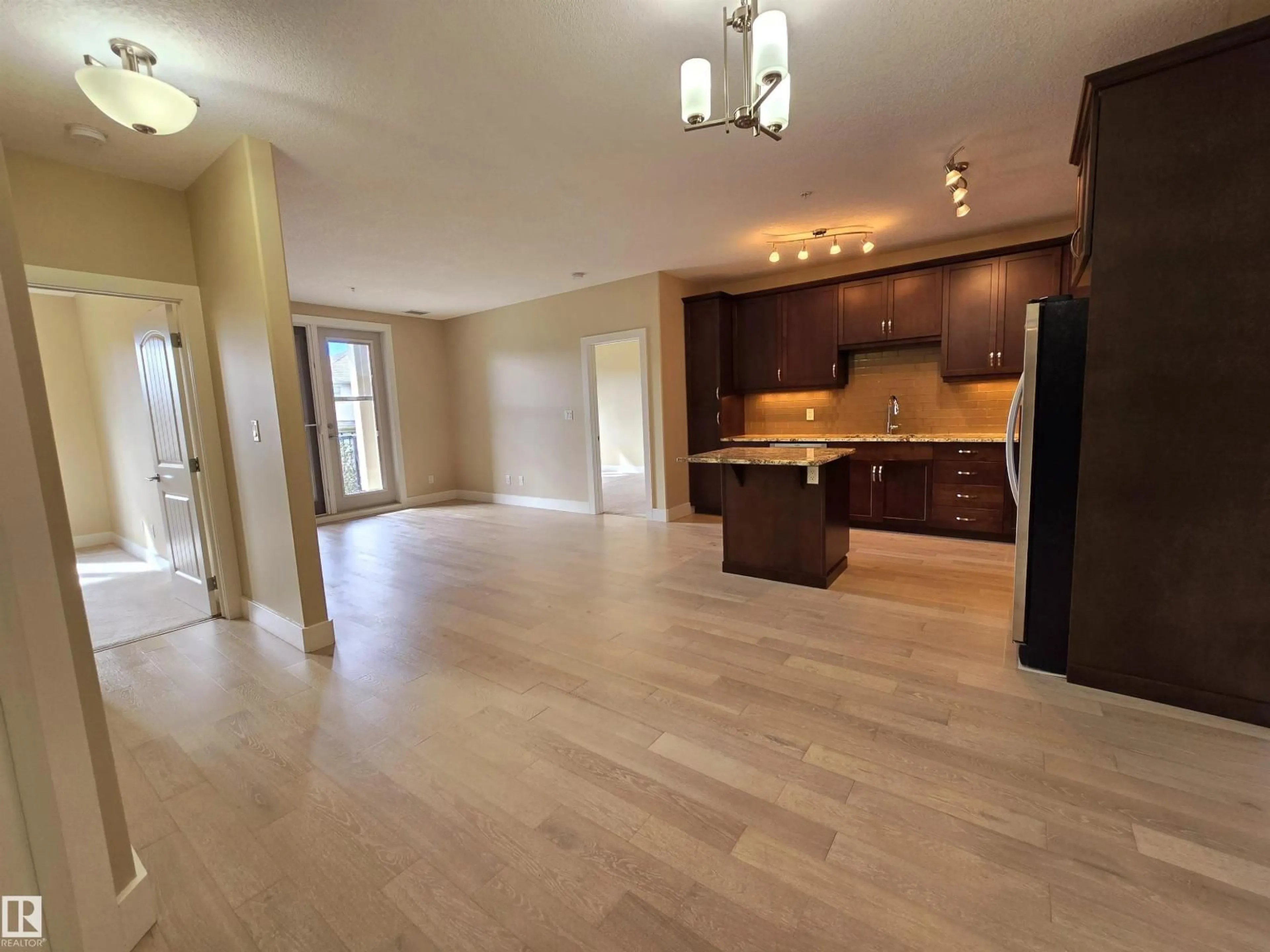 Open concept kitchen, wood/laminate floor for #256 - 6079 MAYNARD WY, Edmonton Alberta T6R0S4