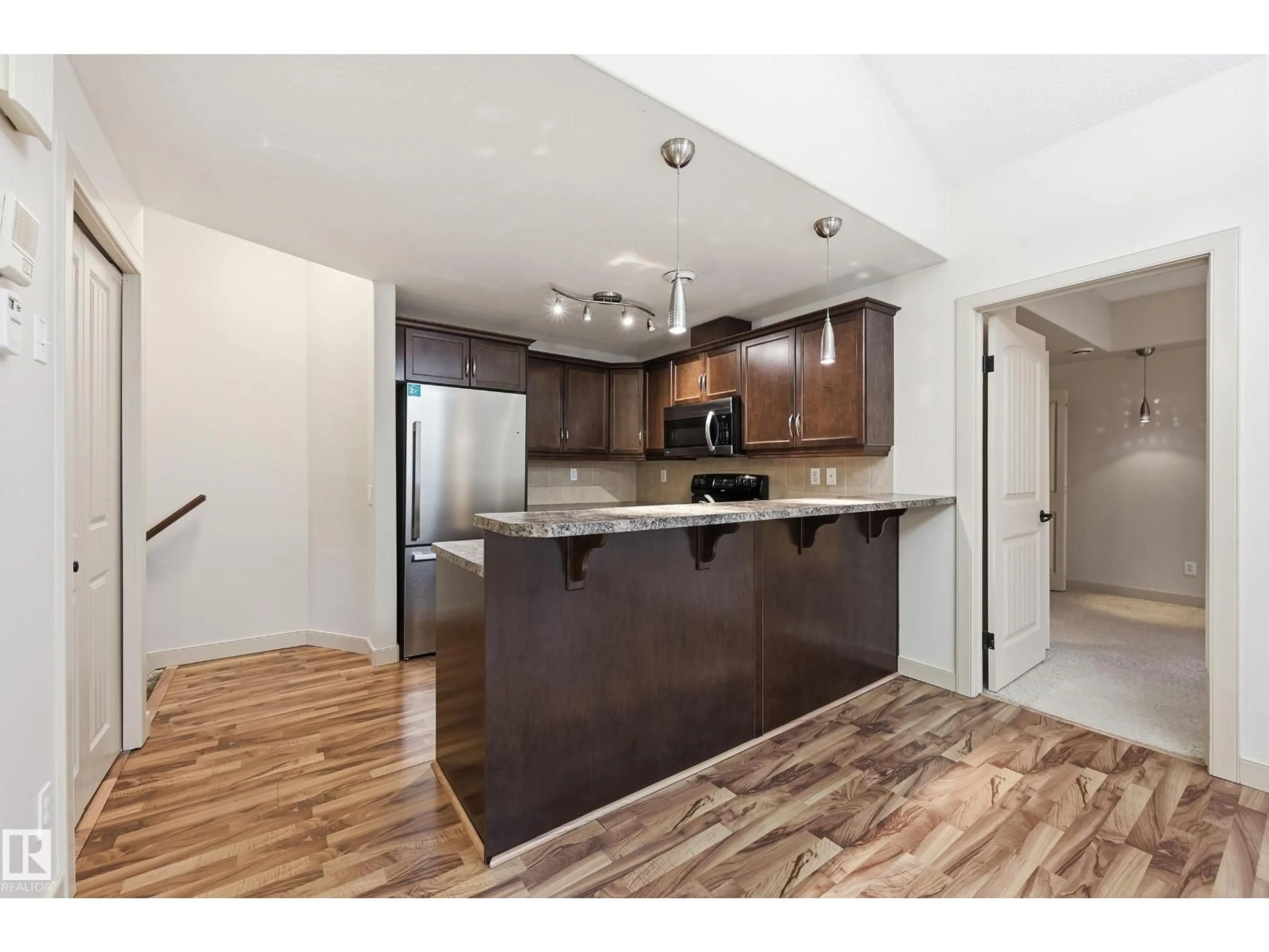 Open concept kitchen, wood/laminate floor for 50 - 2565 HANNA CR, Edmonton Alberta T6R3P7