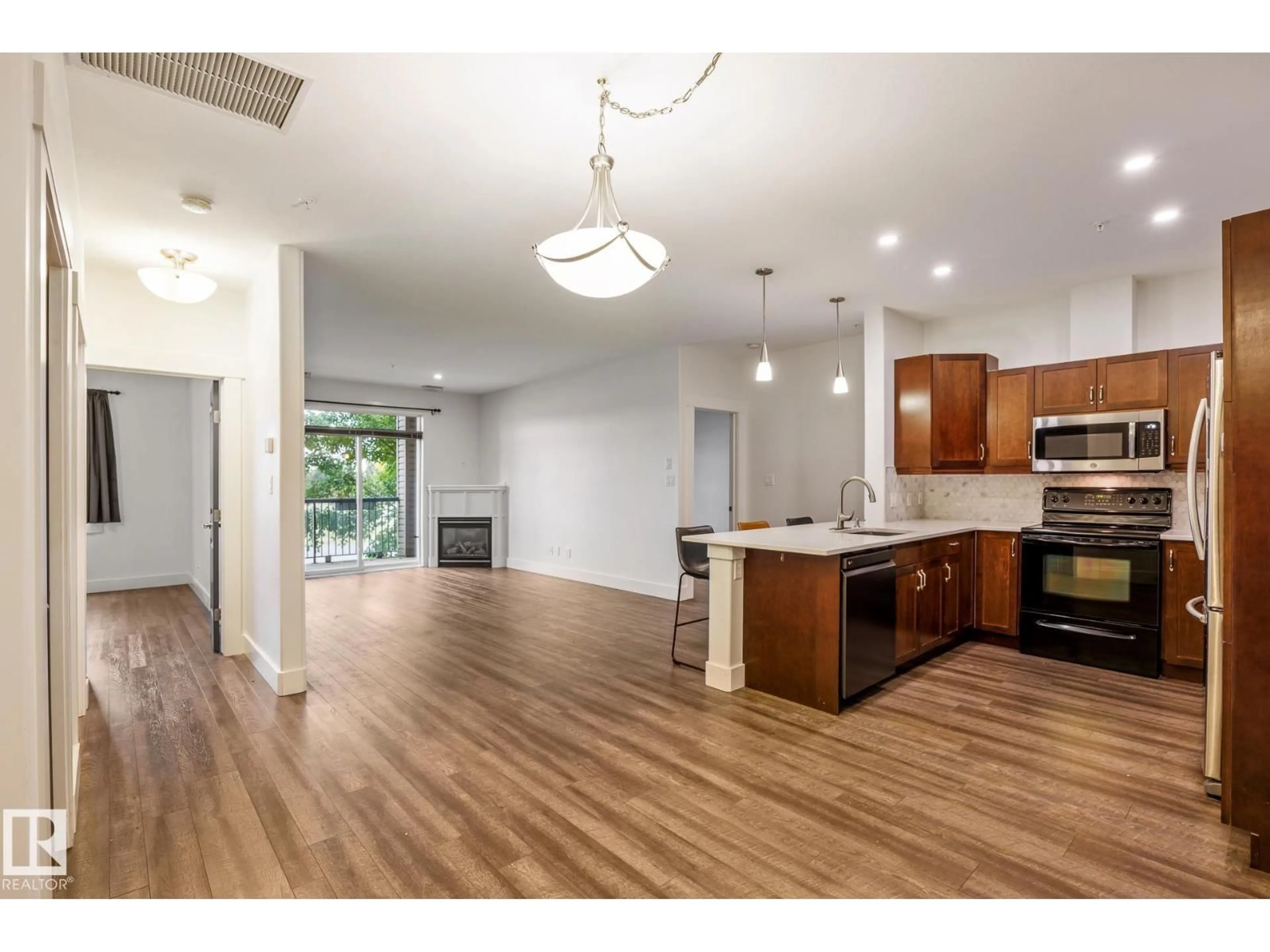 Open concept kitchen, wood/laminate floor for #217 - 2503 HANNA CR, Edmonton Alberta T6R0H1