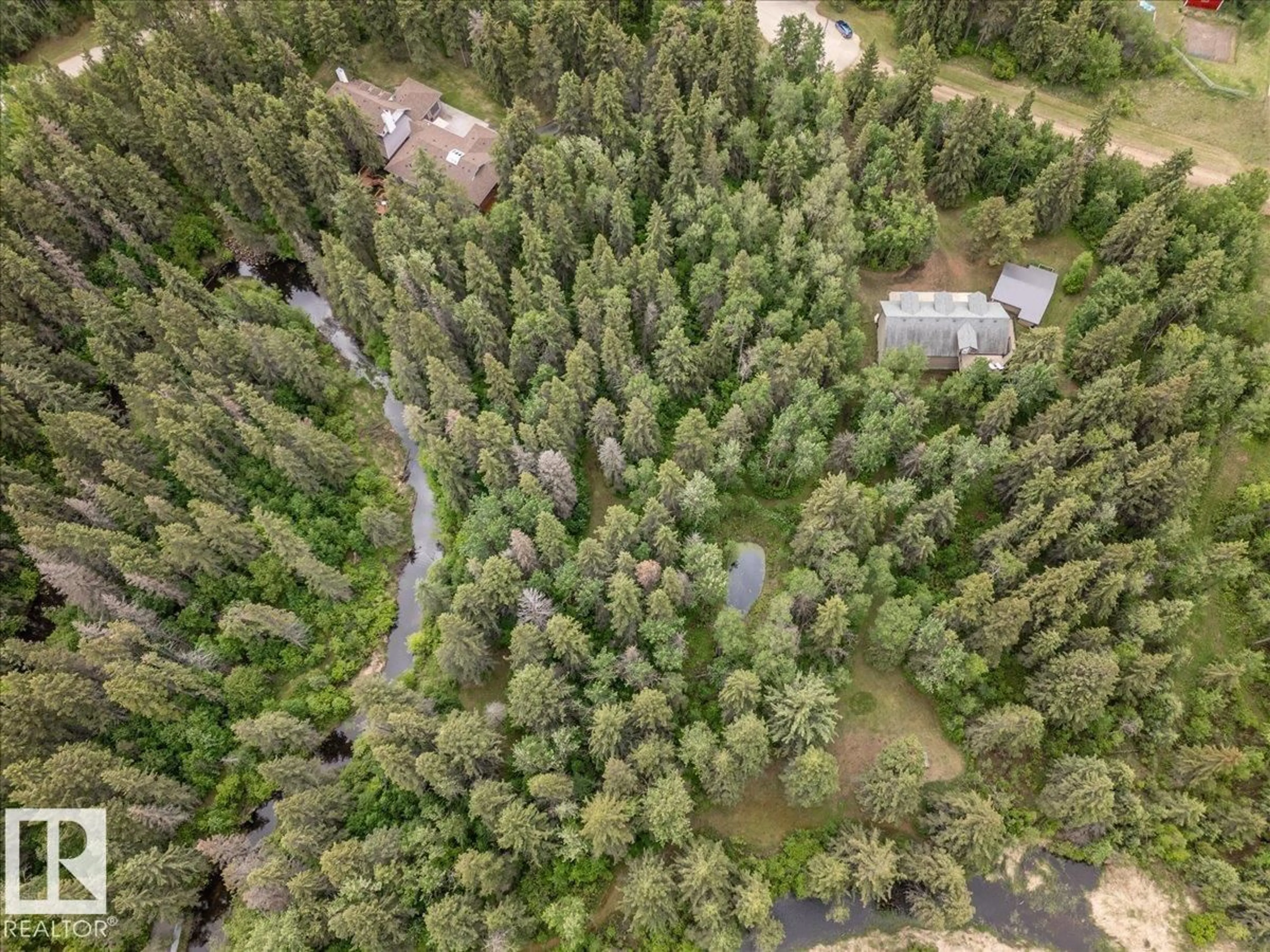 A pic from outside/outdoor area/front of a property/back of a property/a pic from drone, forest/trees view for #104 - 244013 TWP ROAD 470, Rural Wetaskiwin County Alberta T9A1W8