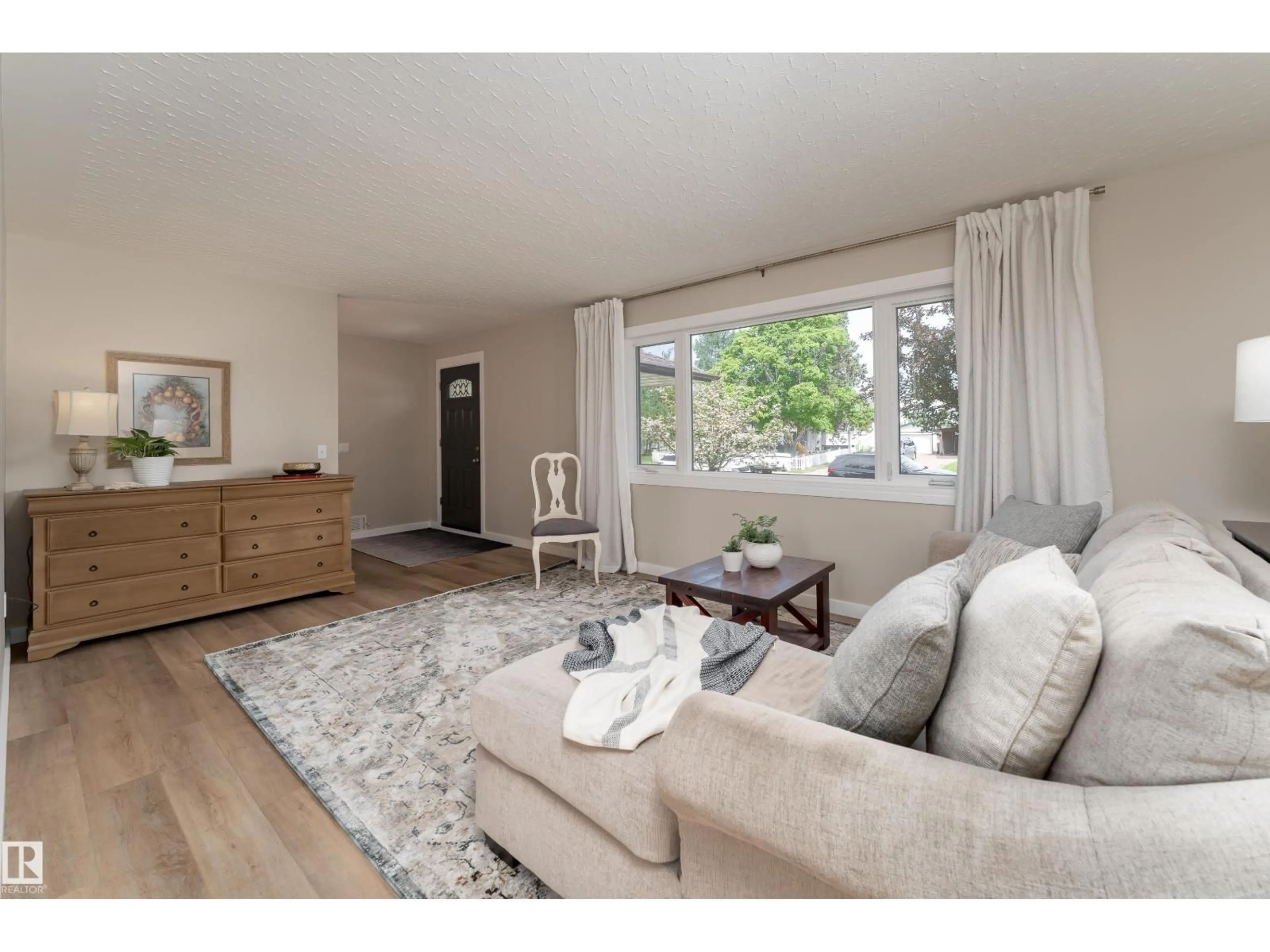Living room with furniture, wood/laminate floor for 7223 95 AV, Edmonton Alberta T6B1B1