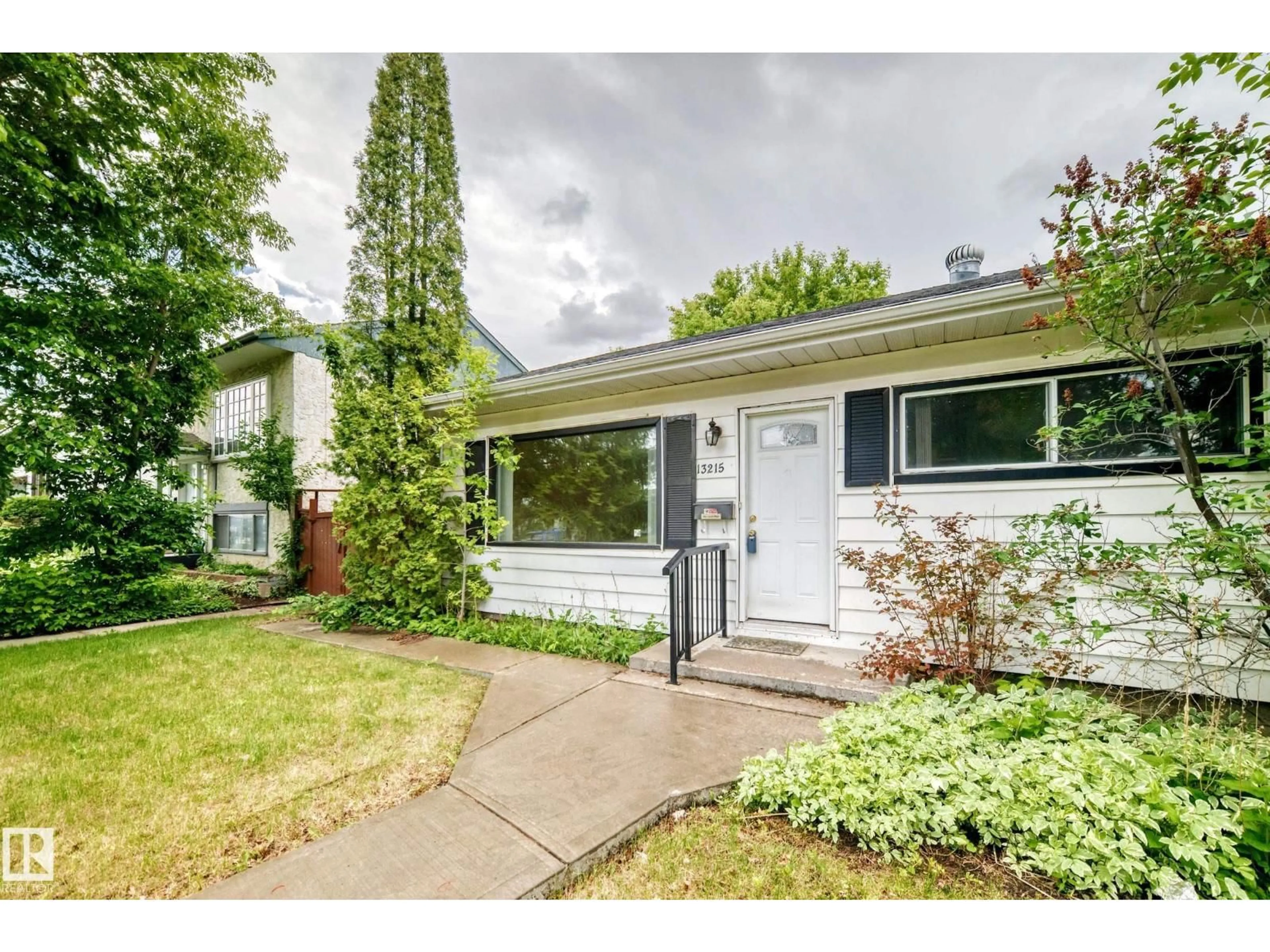 Home with vinyl exterior material, street for 13215 132 AV, Edmonton Alberta T5L3R4