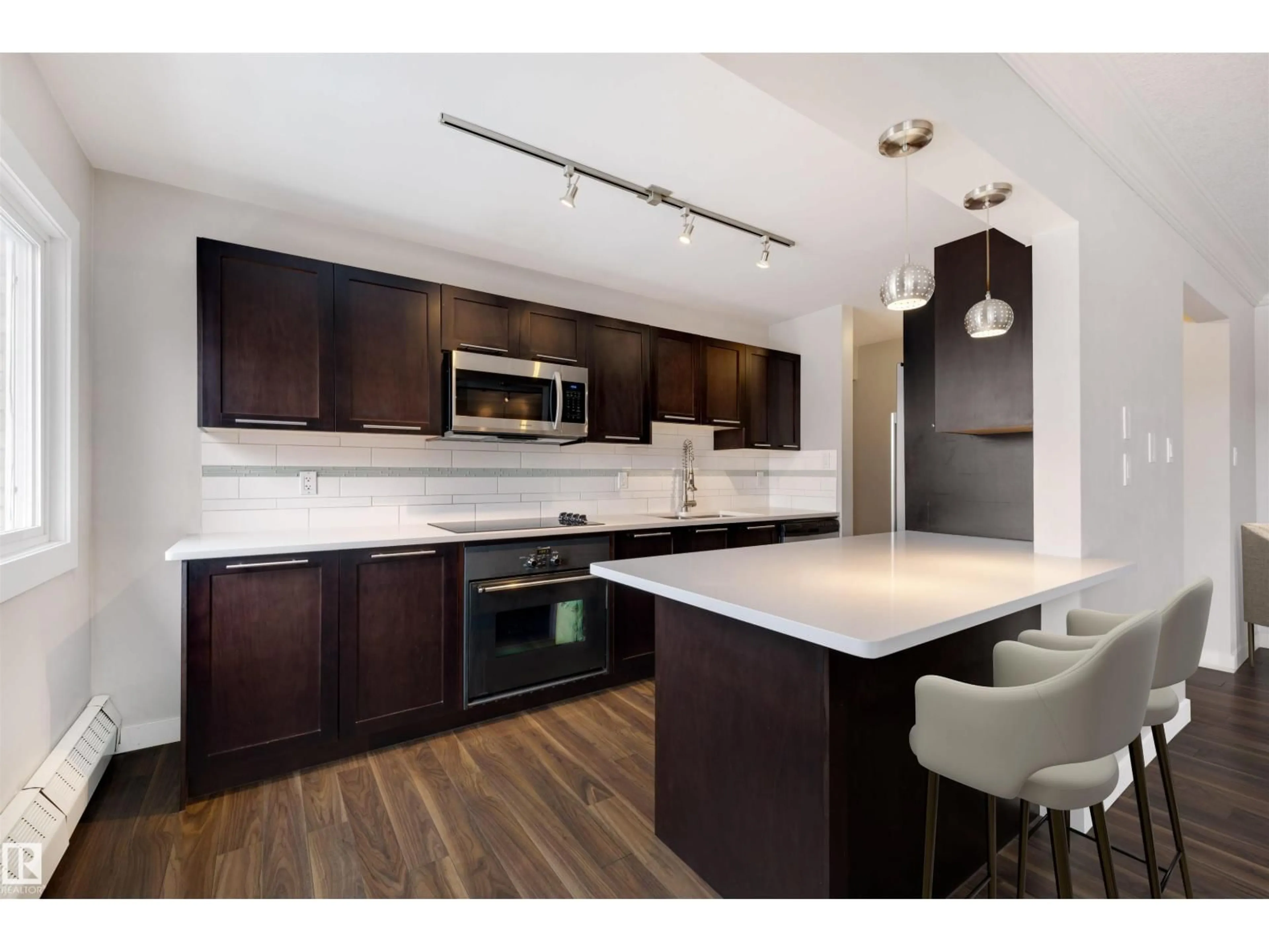 Open concept kitchen, wood/laminate floor for NW - 32 10015 83 AV, Edmonton Alberta T6E2C3