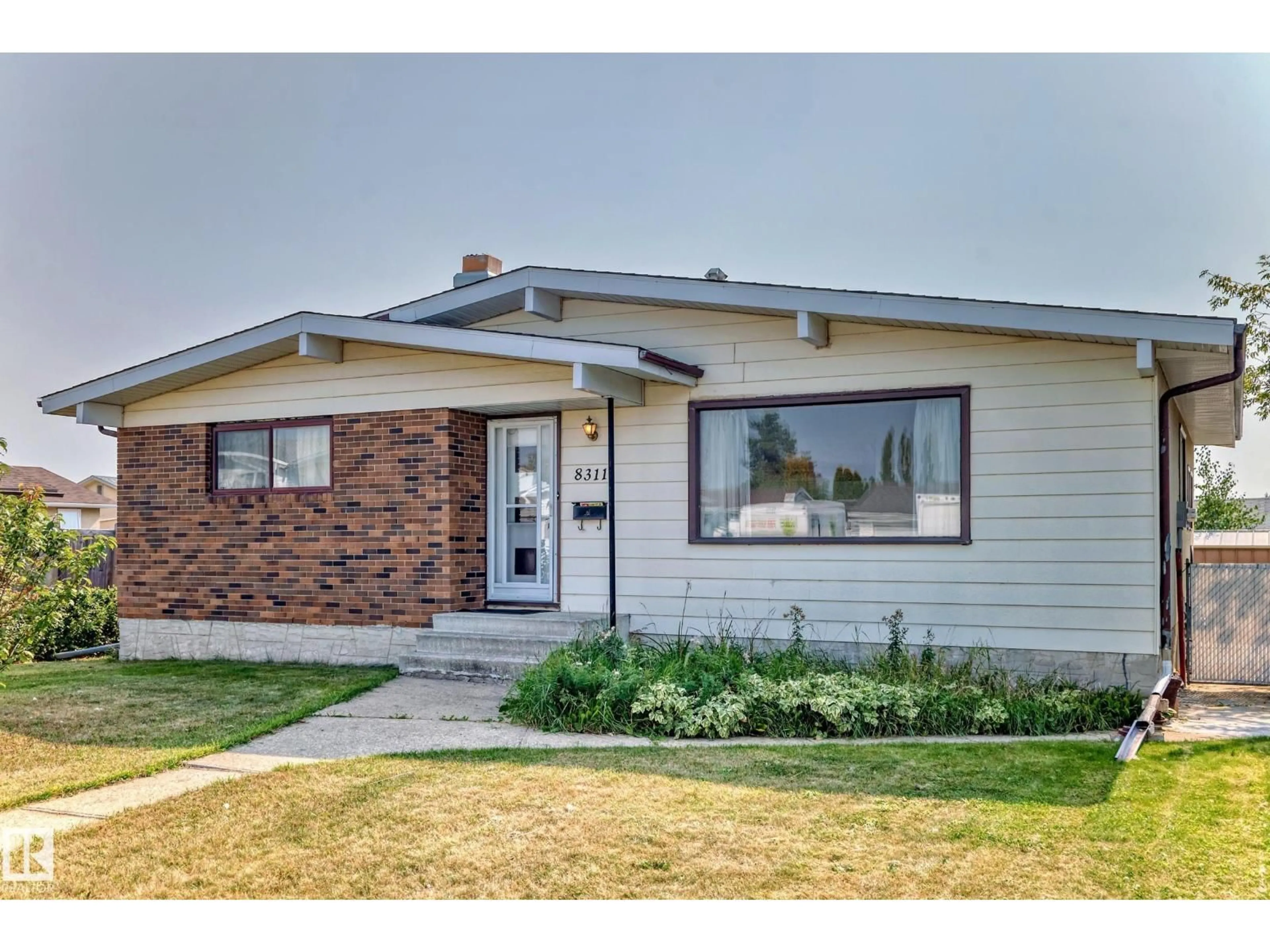 Home with vinyl exterior material, street for 8311 150 AV, Edmonton Alberta T5E1B9