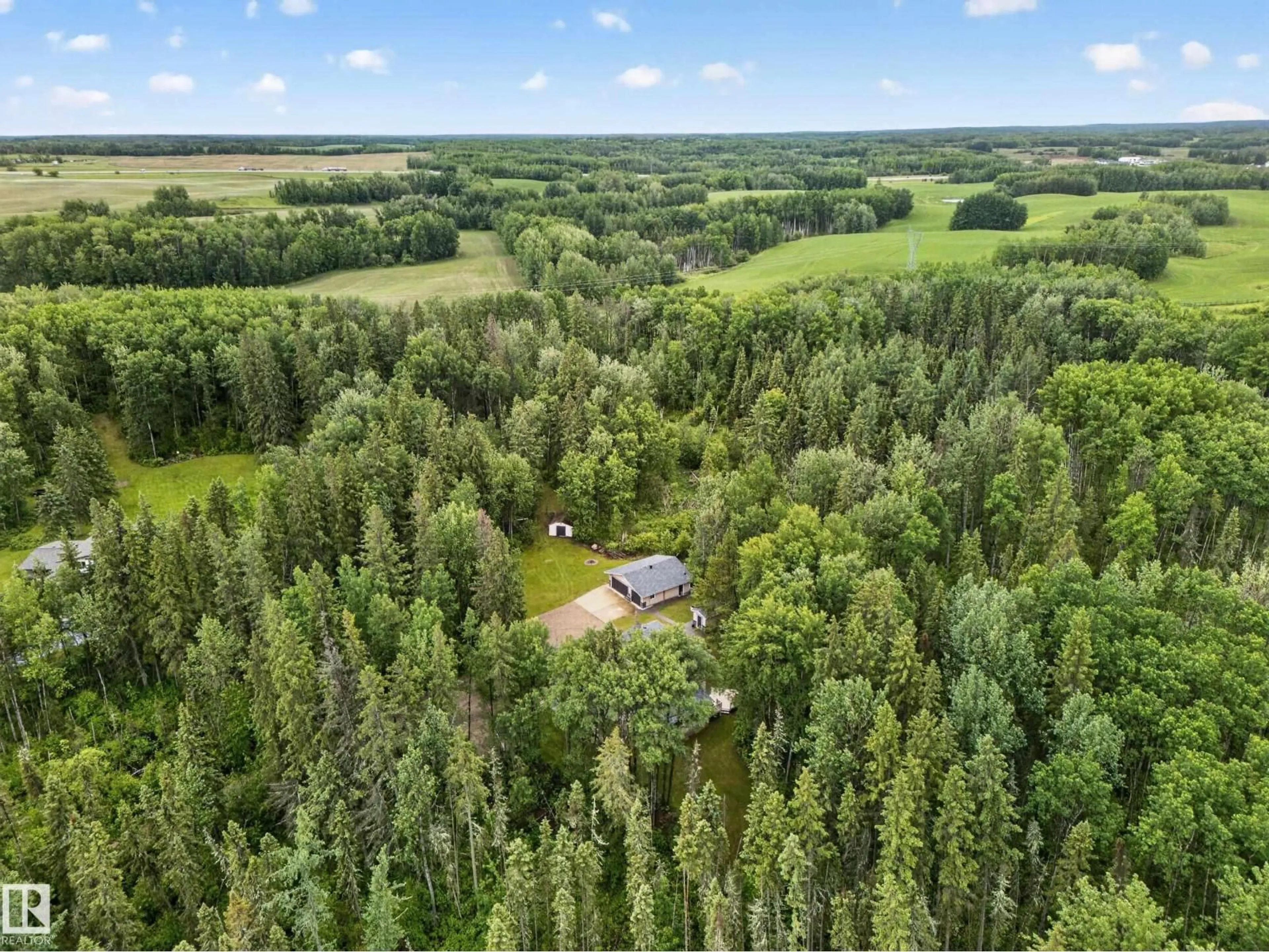 A pic from outside/outdoor area/front of a property/back of a property/a pic from drone, forest/trees view for #8A - 53220 RGE ROAD 21, Rural Parkland County Alberta T7Y0C5