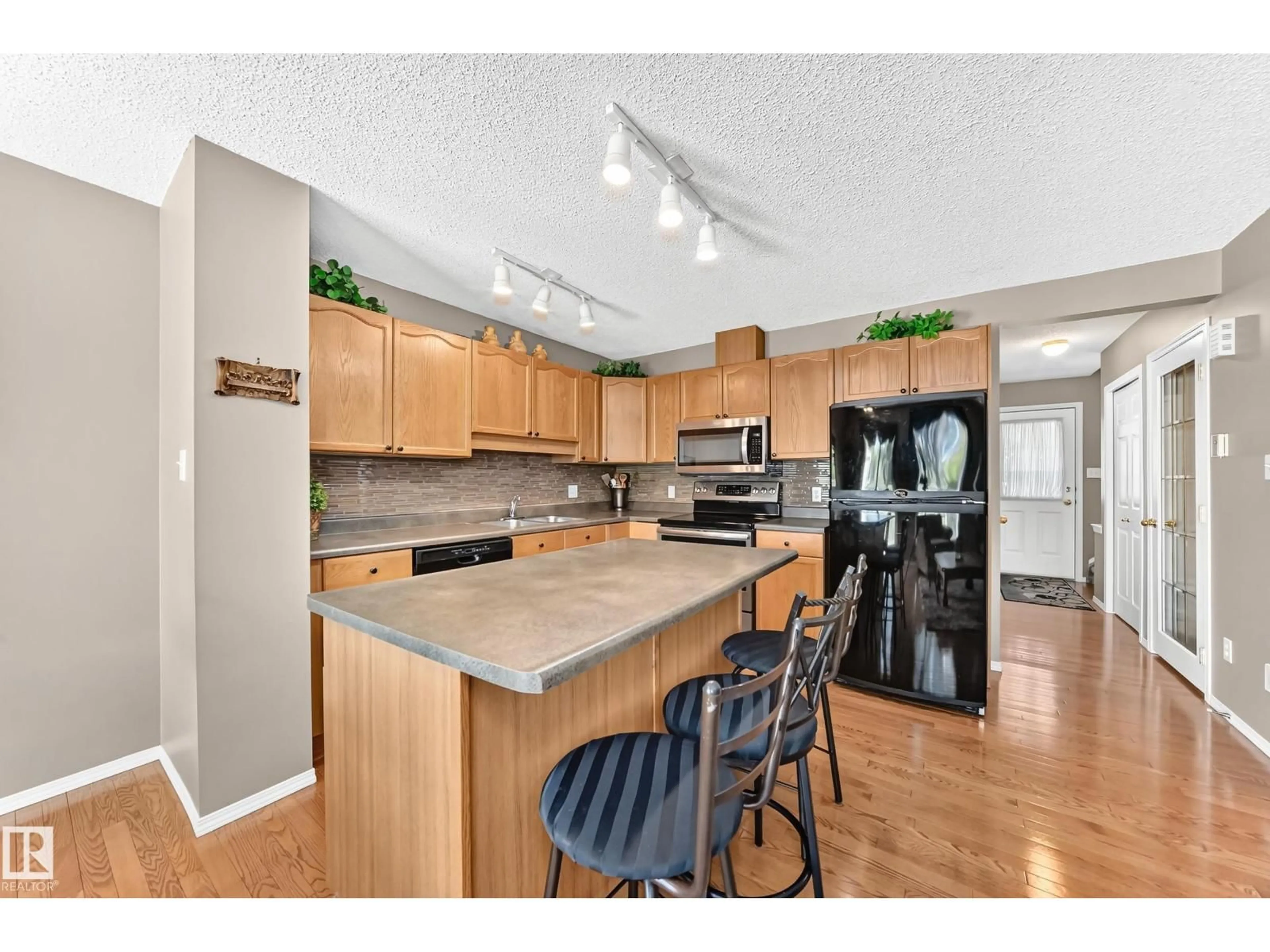 Open concept kitchen, wood/laminate floor for #6 - 14803 MILLER BV, Edmonton Alberta T5Y3A4