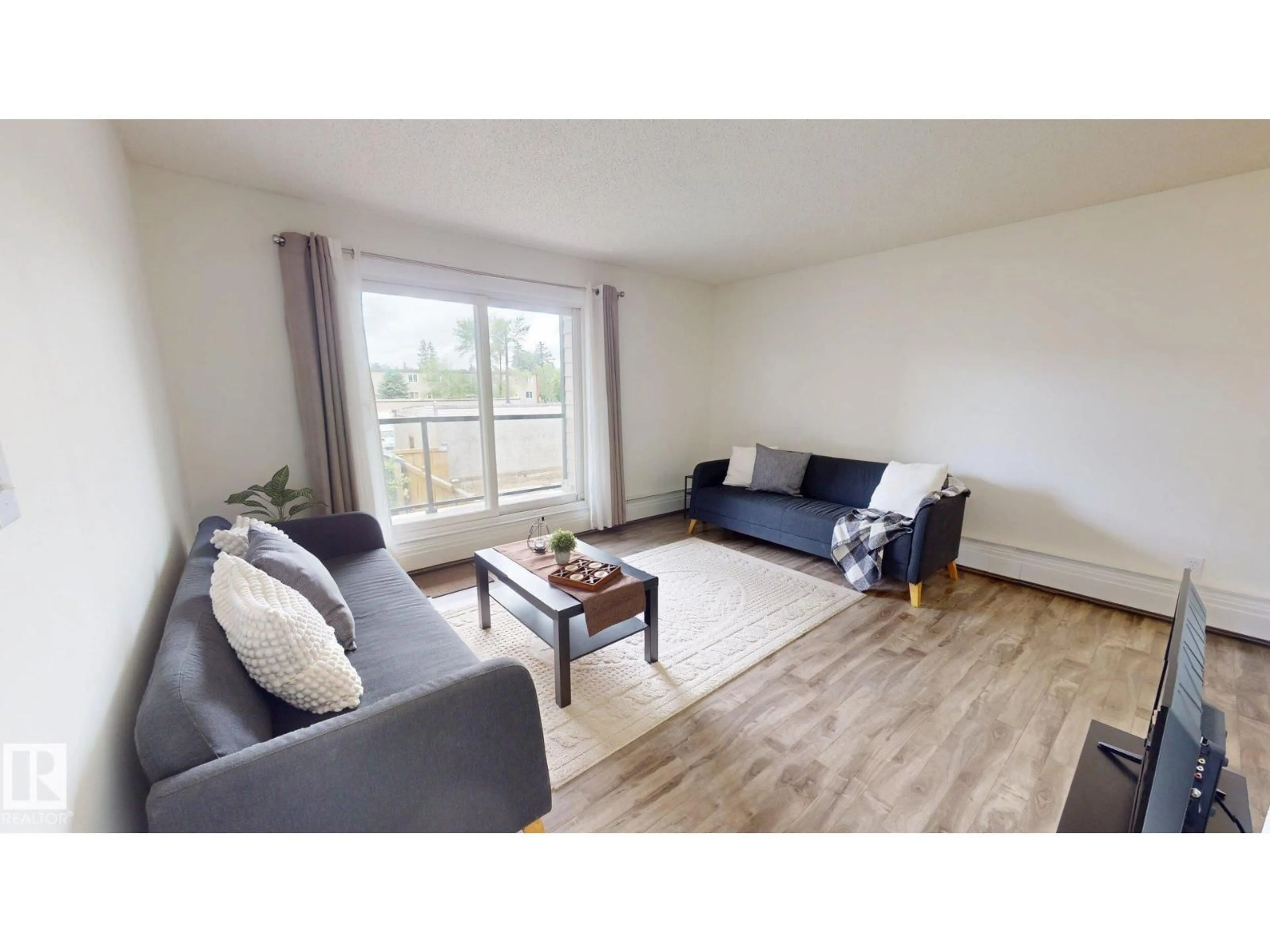 Living room with furniture, wood/laminate floor for 207 - 11224 116 ST NW, Edmonton Alberta T5G2W1
