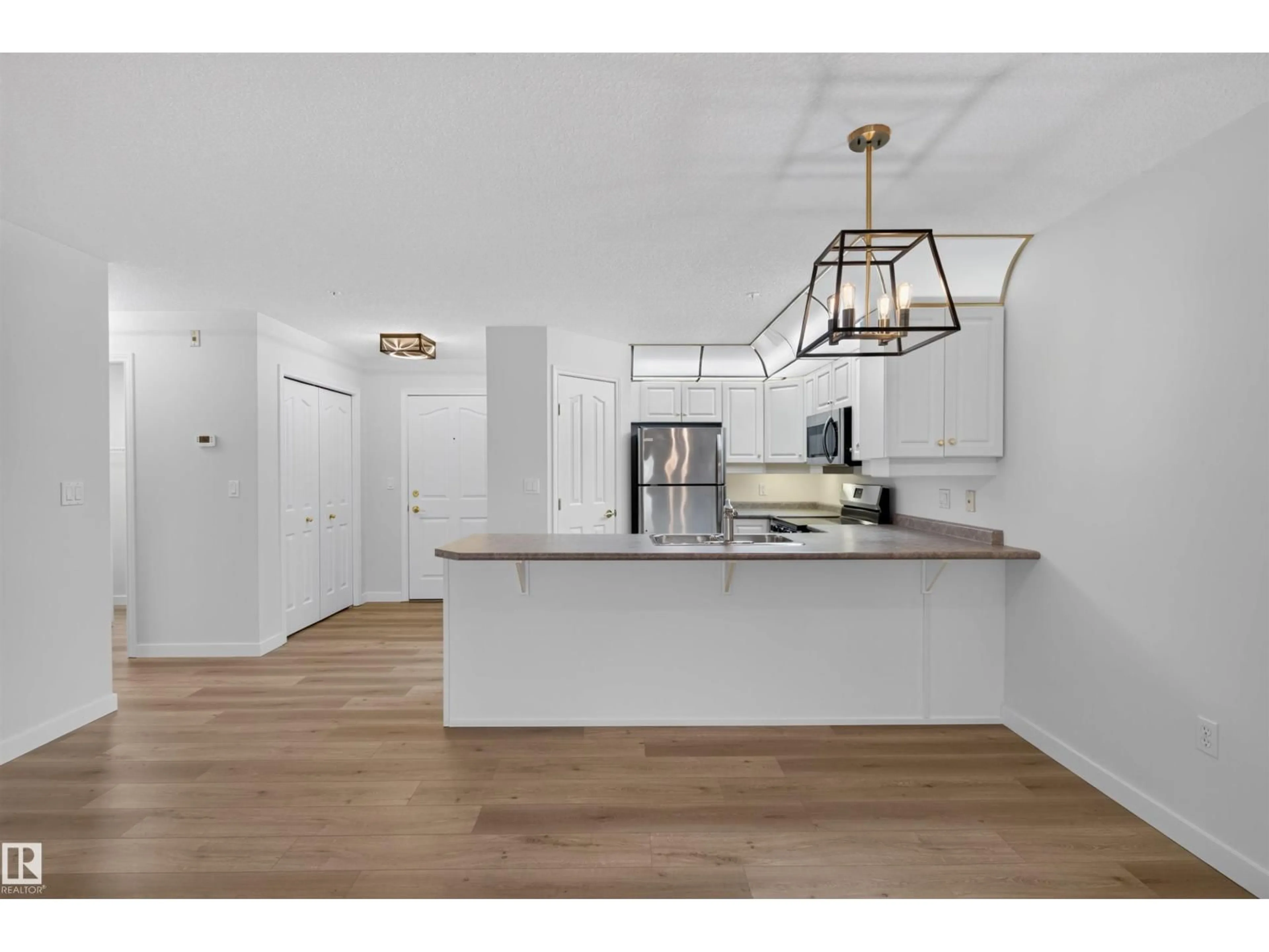 Open concept kitchen, wood/laminate floor for #215 - 6703 172 ST, Edmonton Alberta T5T6H9