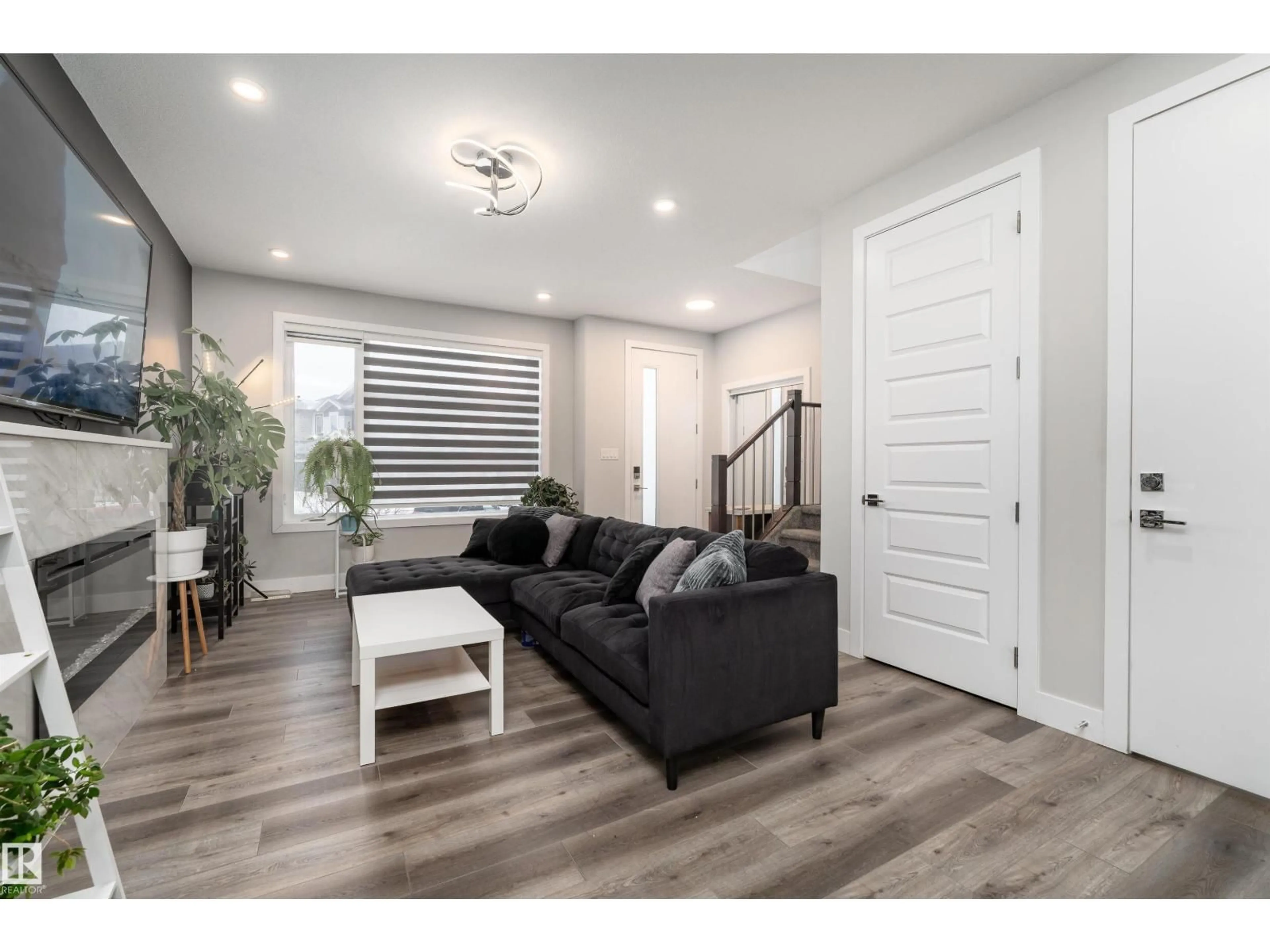 Living room with furniture, wood/laminate floor for 9338 PEAR LI SW, Edmonton Alberta T6X2V9