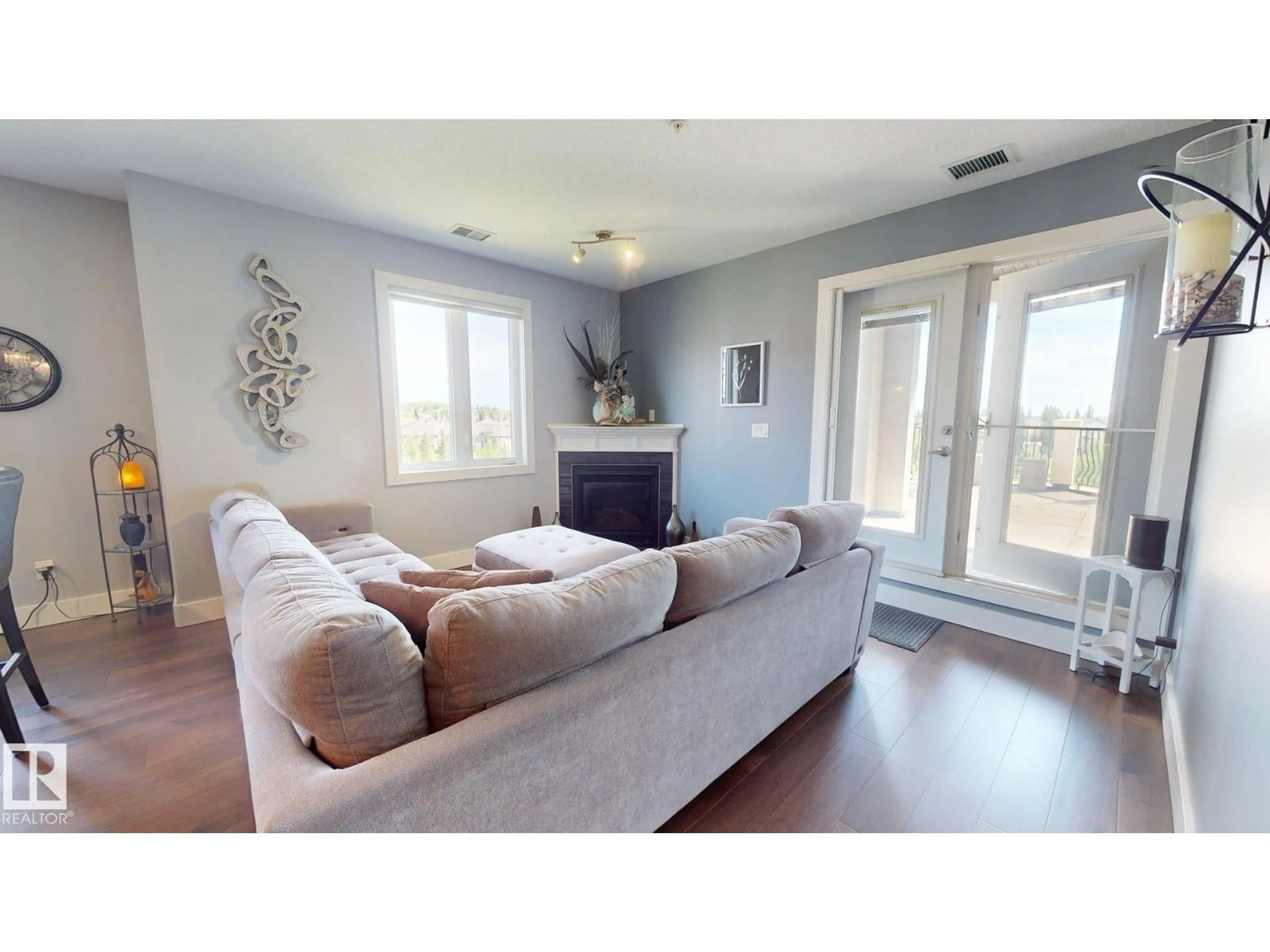 Living room with furniture, wood/laminate floor for 6079 - 355 MAYNARD WY, Edmonton Alberta T6R0S4