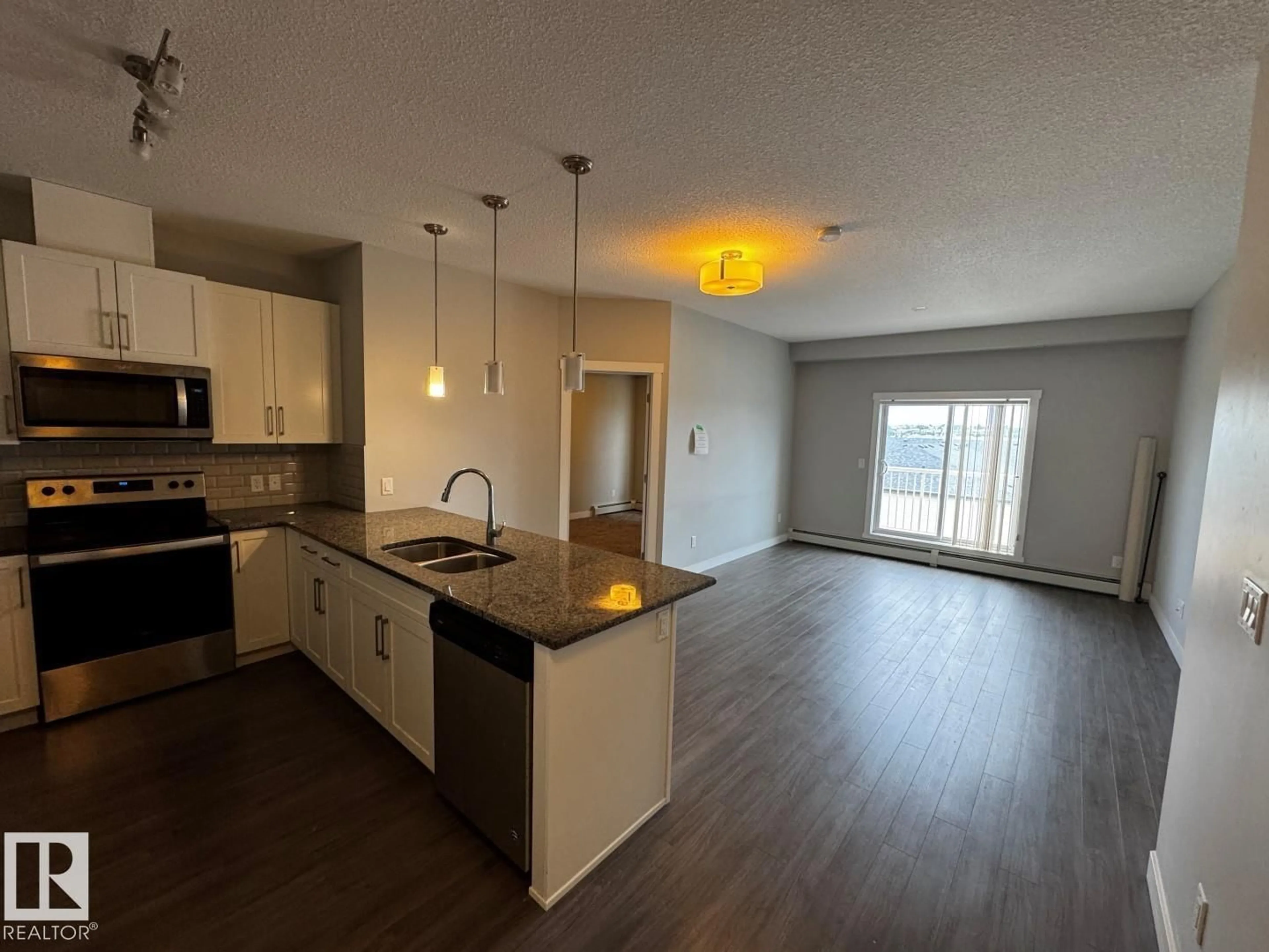 Open concept kitchen, wood/laminate floor for #405 - 3670 139 AV, Edmonton Alberta T5Y3N5