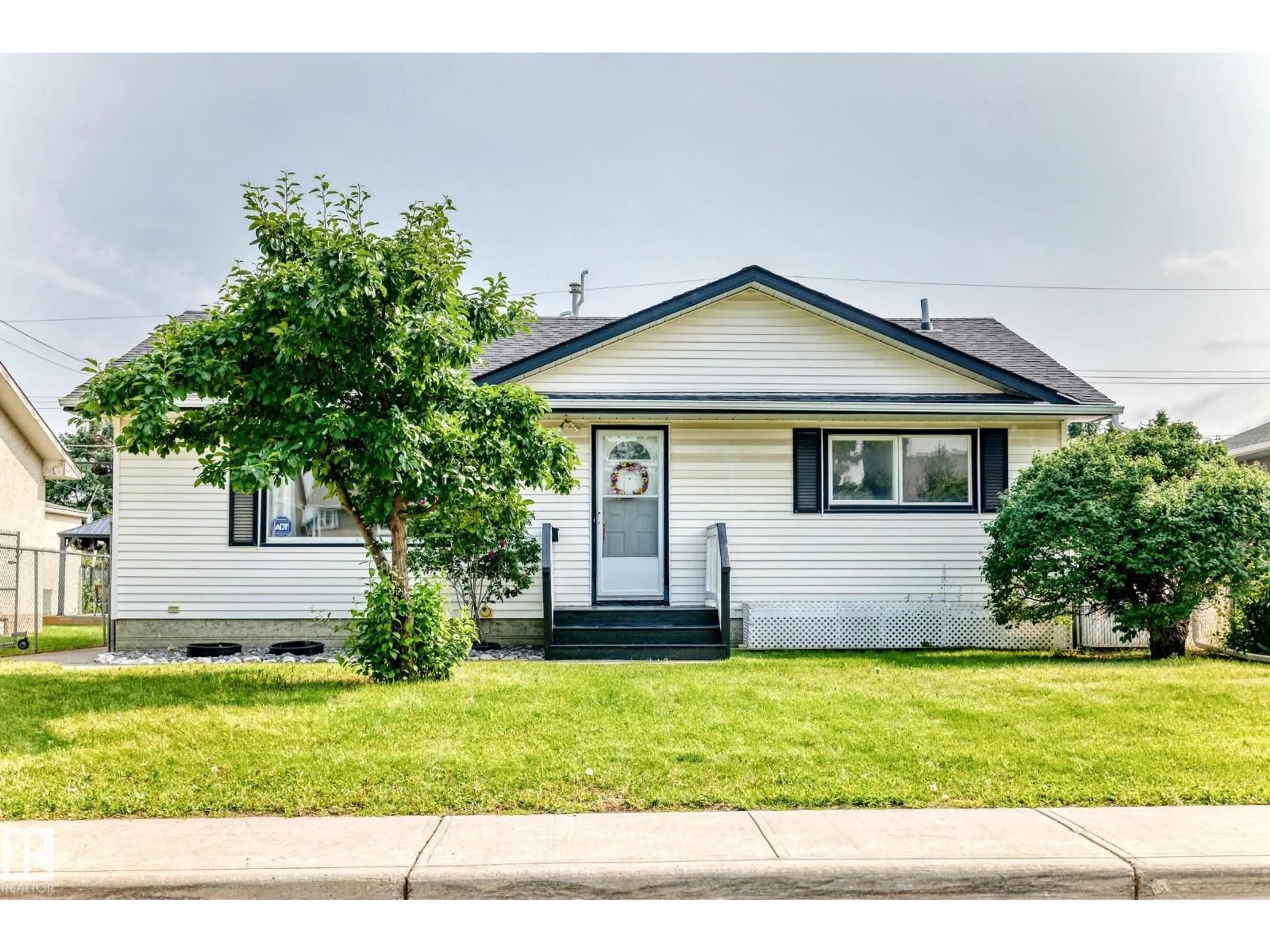 Home with vinyl exterior material, street for 10819 137 AV, Edmonton Alberta T5E1Z2