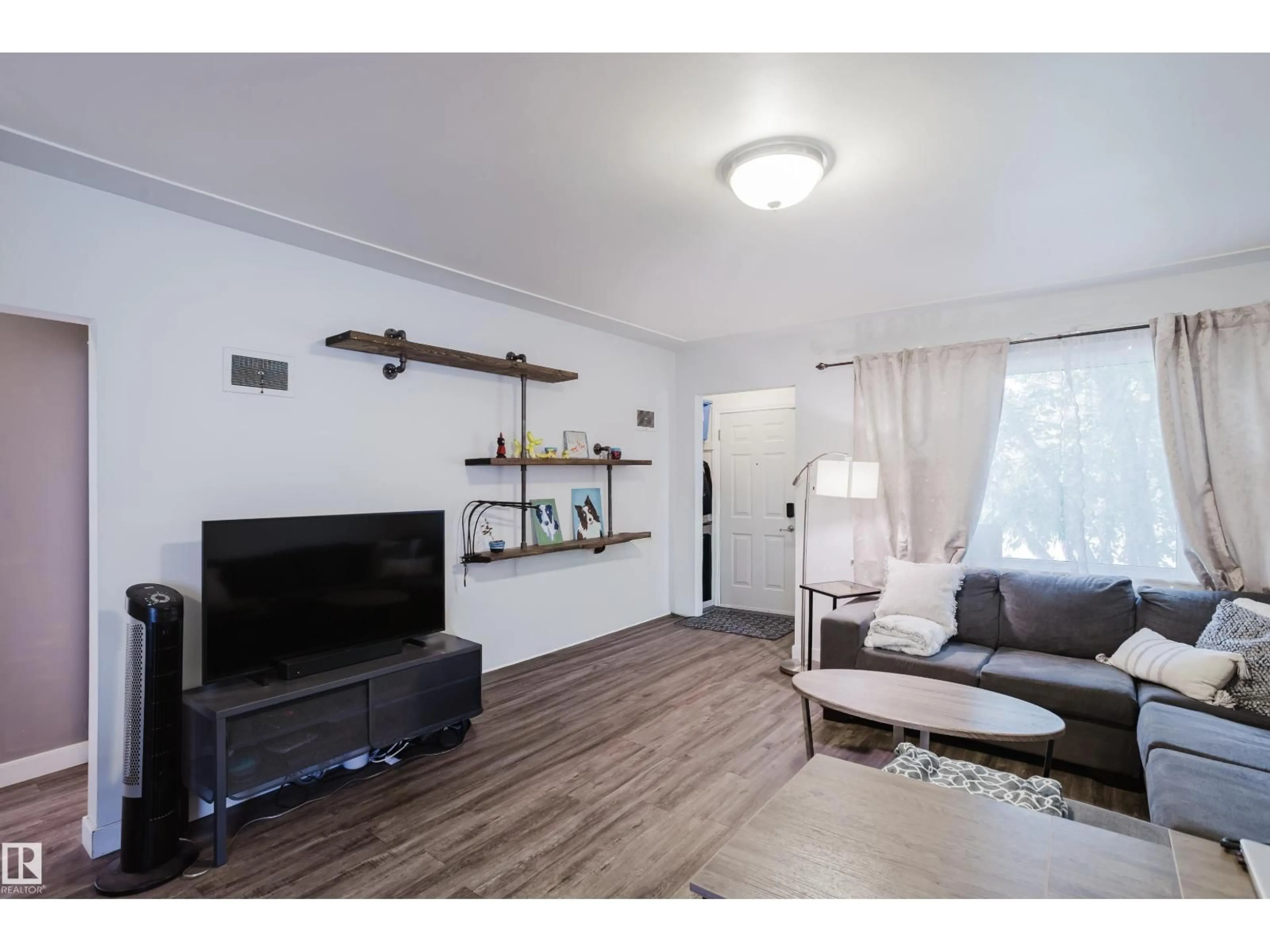 Living room with furniture, wood/laminate floor for 10623 76 AV, Edmonton Alberta T6E1L6