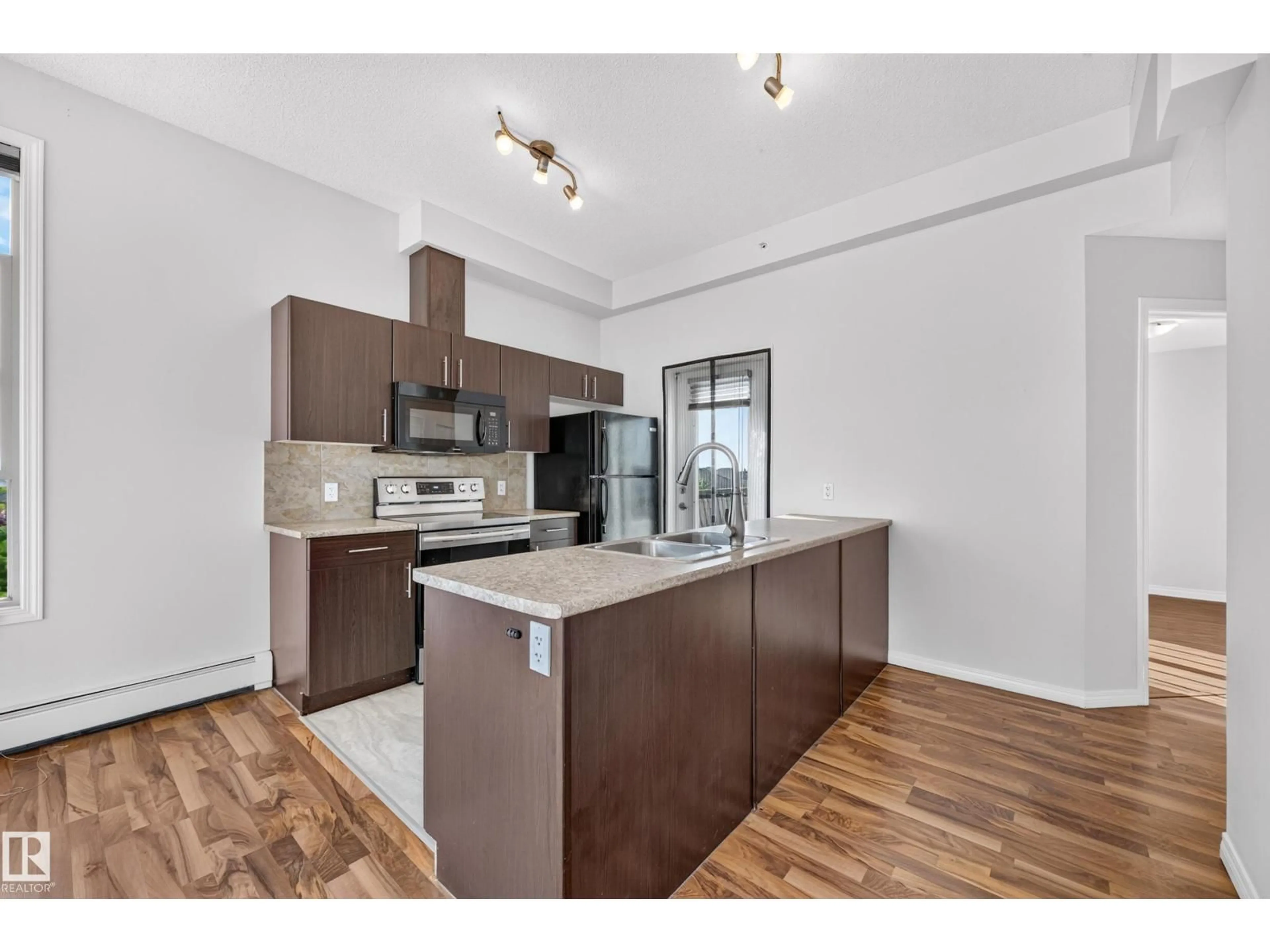 Open concept kitchen, wood/laminate floor for #406 - 105 AMBLESIDE DR, Edmonton Alberta T6W0J4