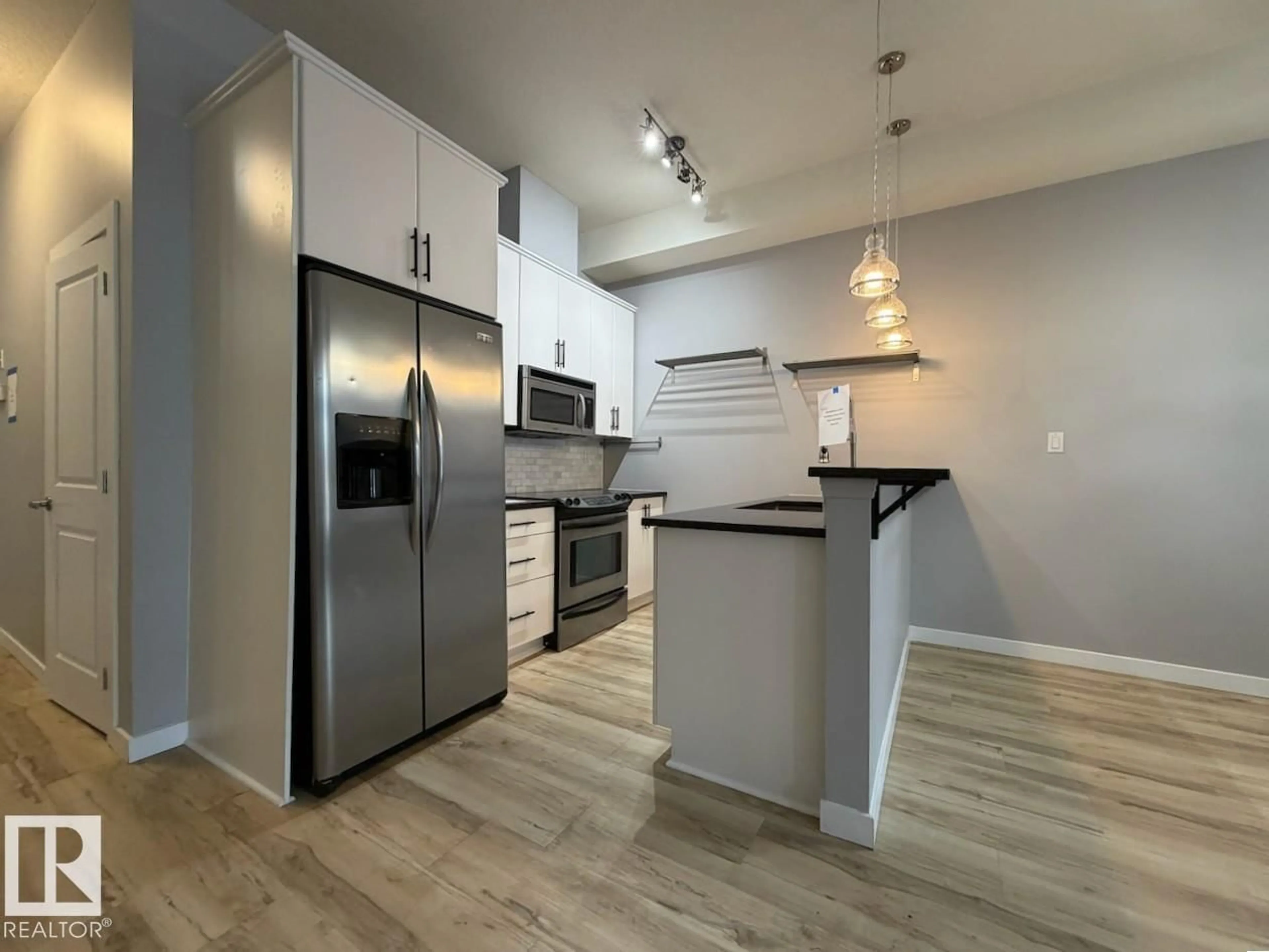 Open concept kitchen, wood/laminate floor for #128 - 10531 117 ST, Edmonton Alberta T5H0A8