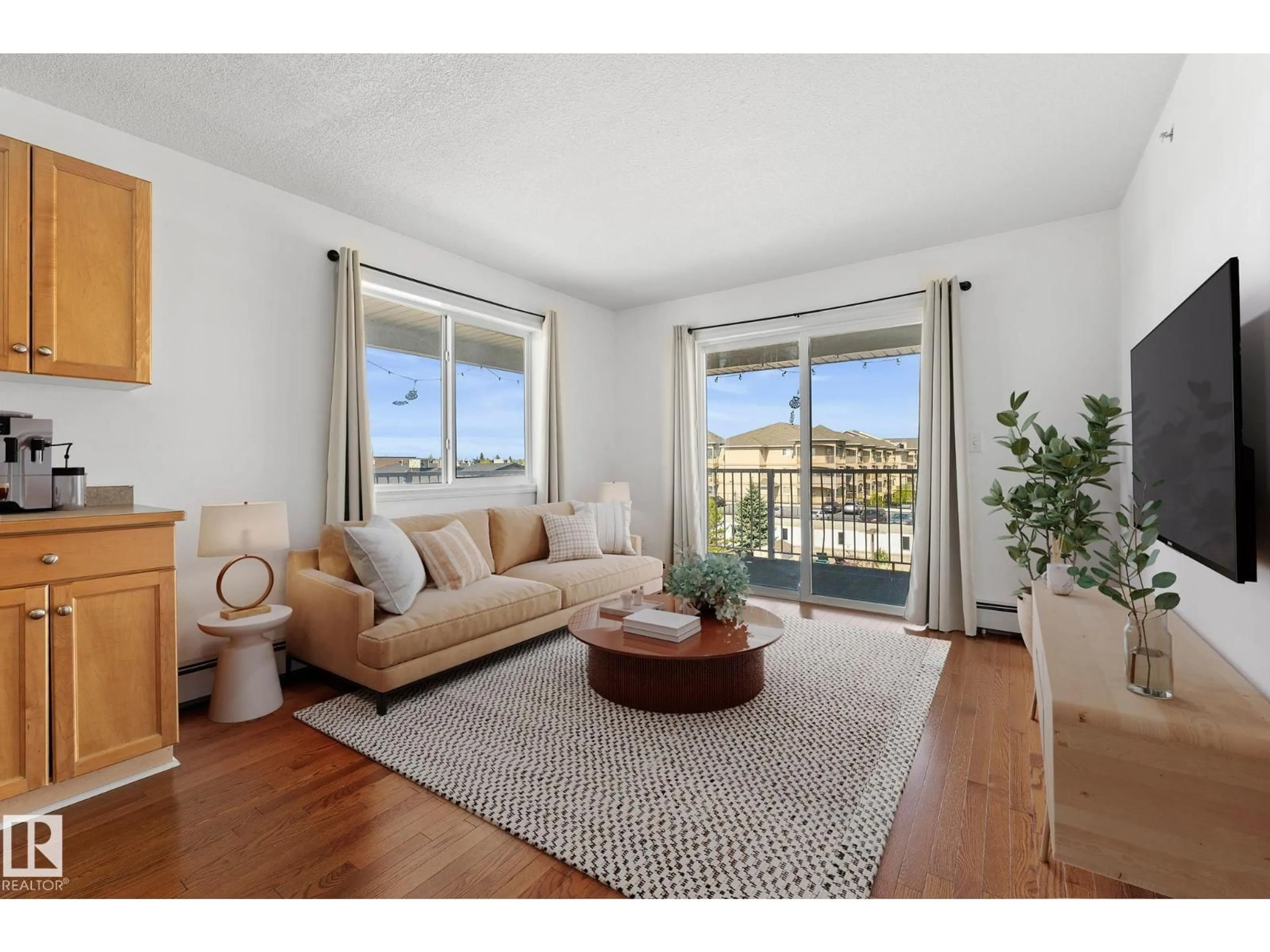 Living room with furniture, wood/laminate floor for 420 - 12550 140 AV NW, Edmonton Alberta T5X6J4