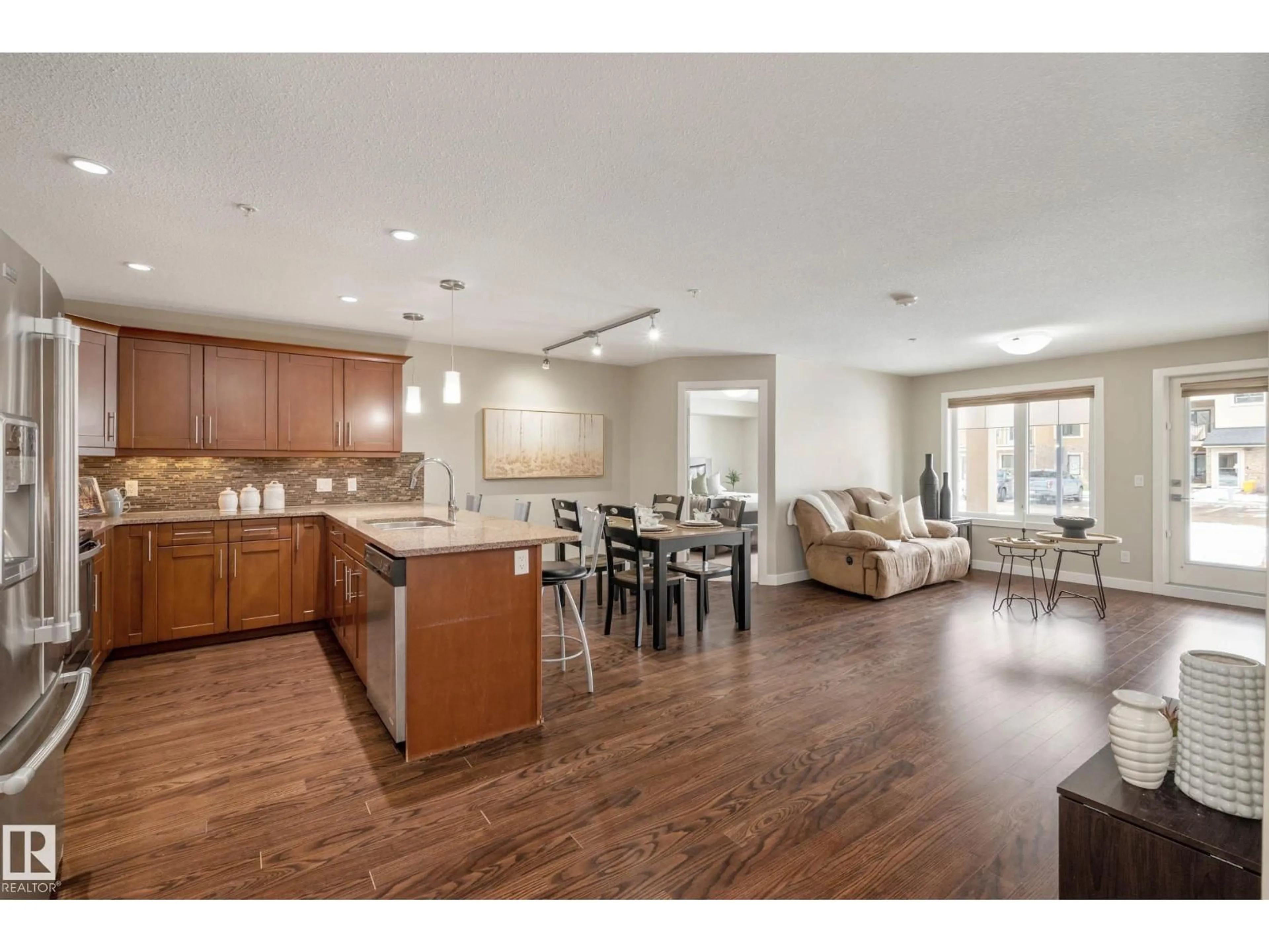 Open concept kitchen, wood/laminate floor for #119 - 1031 173 ST, Edmonton Alberta T6W3E4