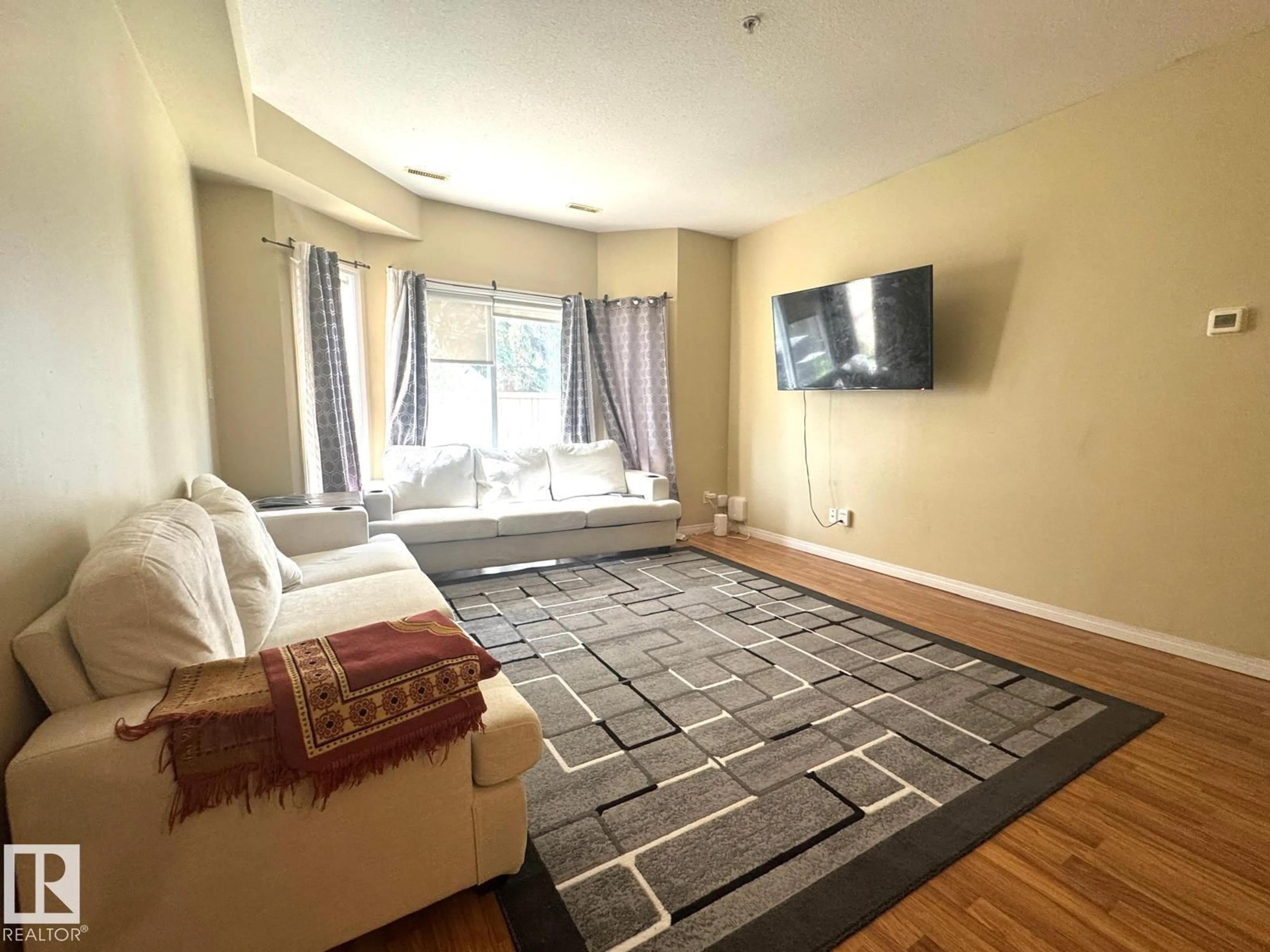 Living room with furniture, carpet floor for #117 - 4304 139 AV, Edmonton Alberta T5Y0H6