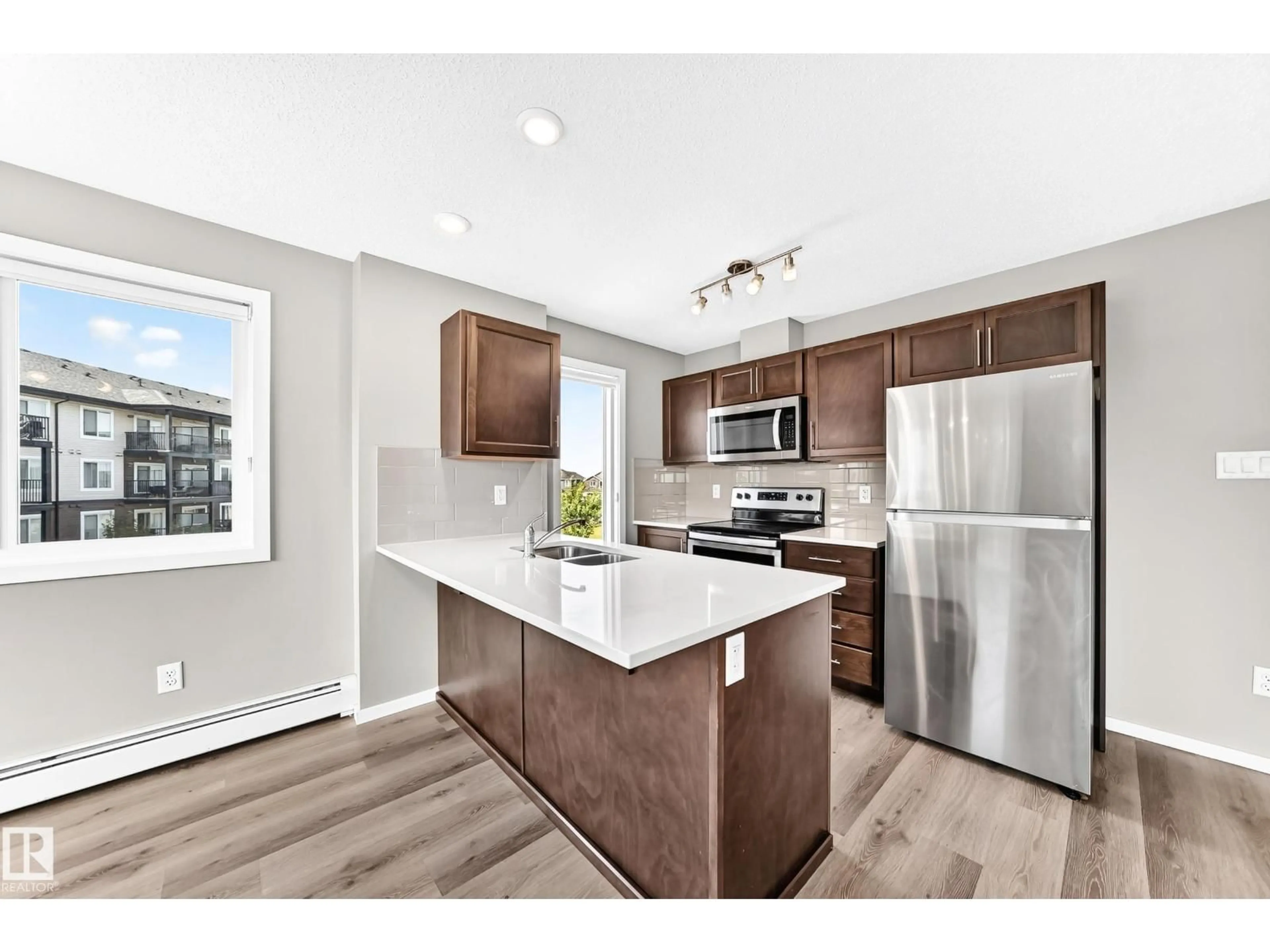 Open concept kitchen, wood/laminate floor for 322 EBBERS BV, Edmonton Alberta T5Y3W2
