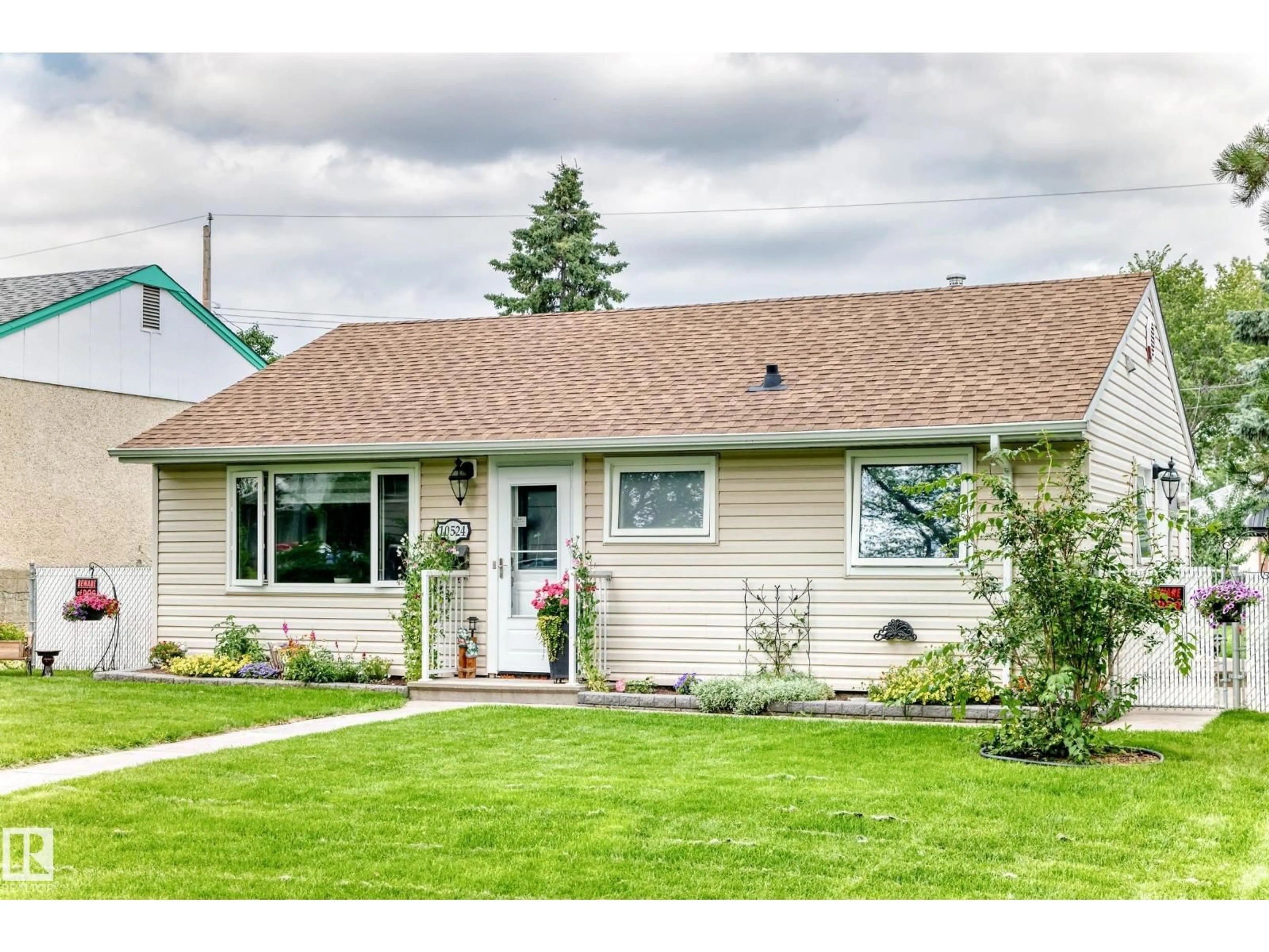 Home with vinyl exterior material, street for 10524 128 AV, Edmonton Alberta T5E0J3