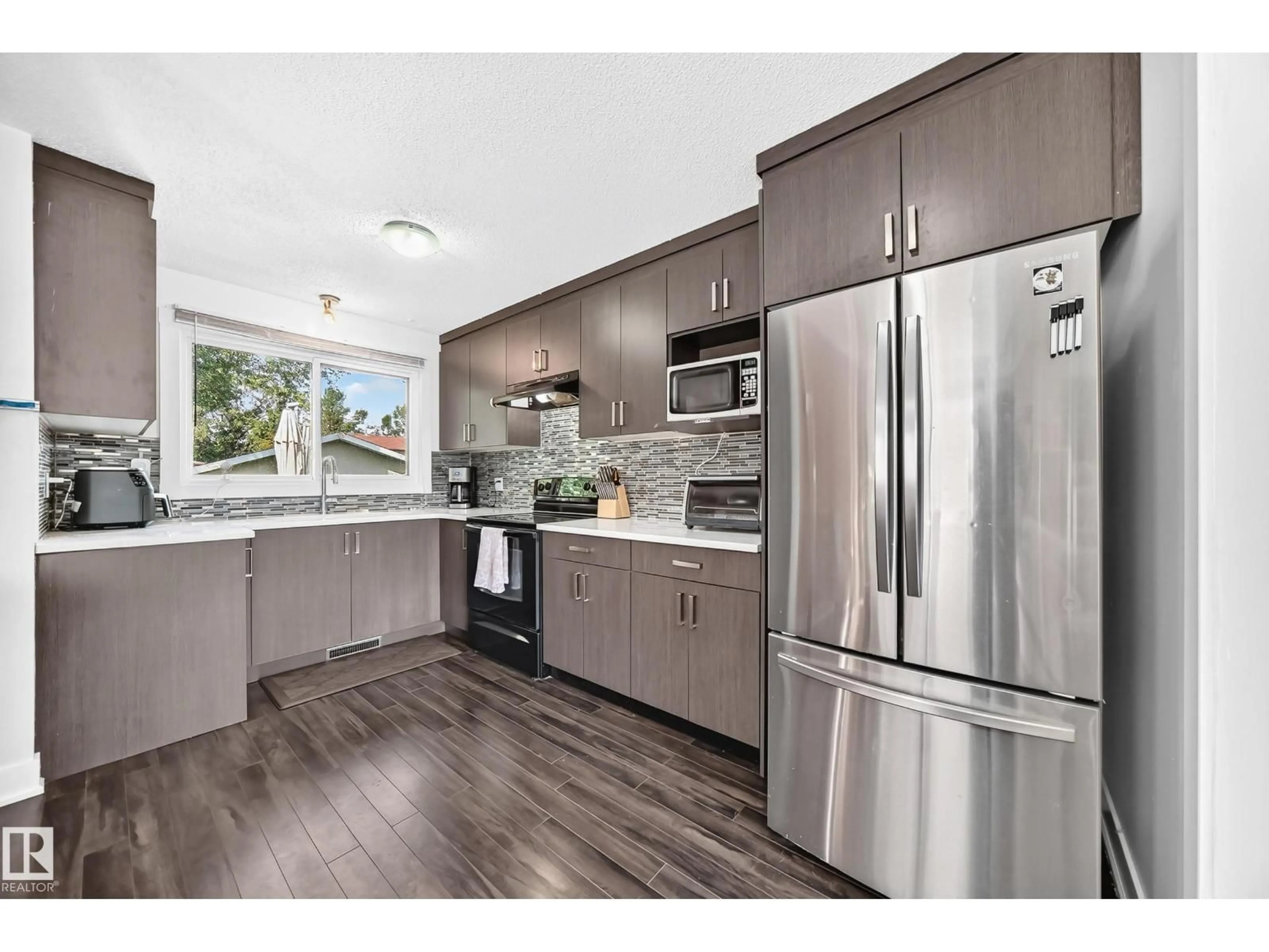 Open concept kitchen, wood/laminate floor for 2112 36 ST, Edmonton Alberta T6L3G4