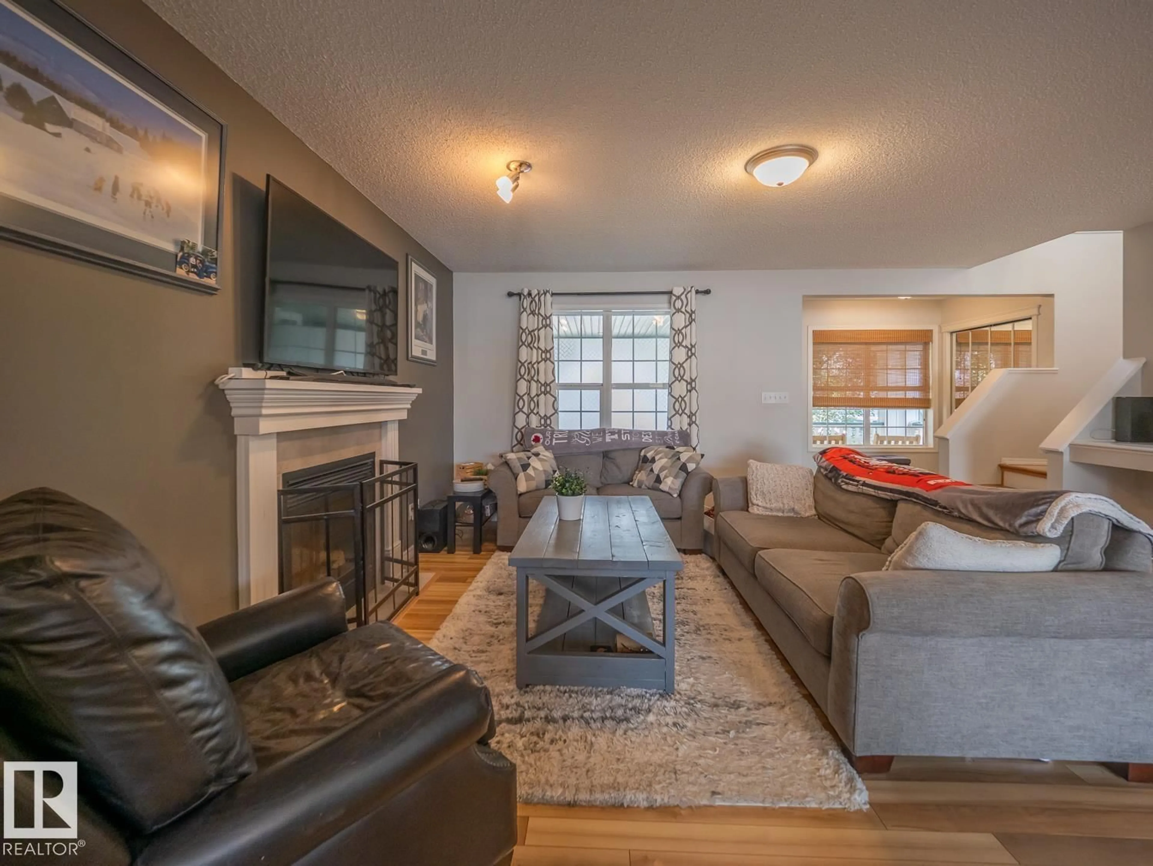Living room with furniture, wood/laminate floor for SW - 12124 17 AV, Edmonton Alberta T6W1M1