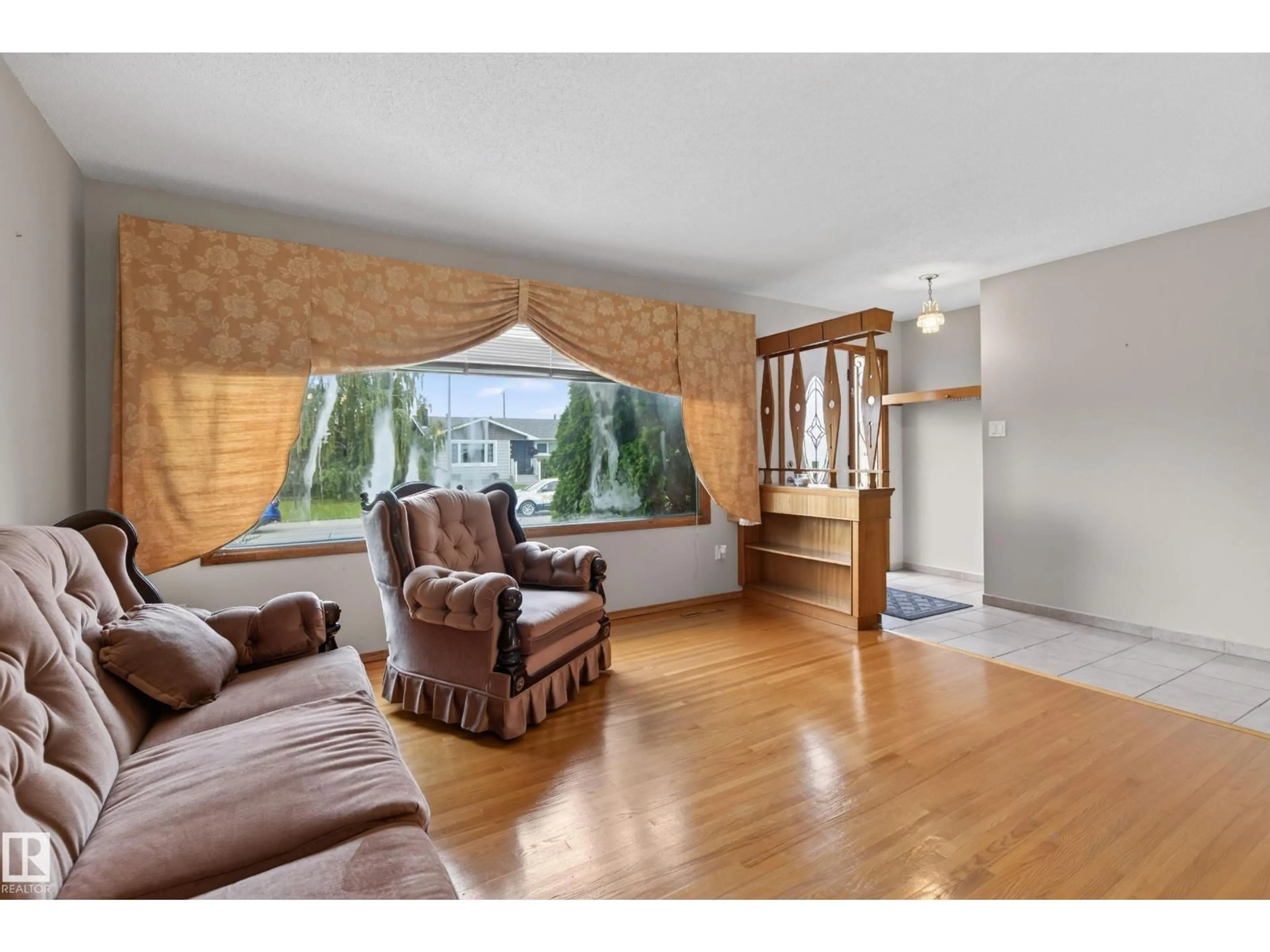 Living room with furniture, wood/laminate floor for 8411 136 AV, Edmonton Alberta T5E1T9
