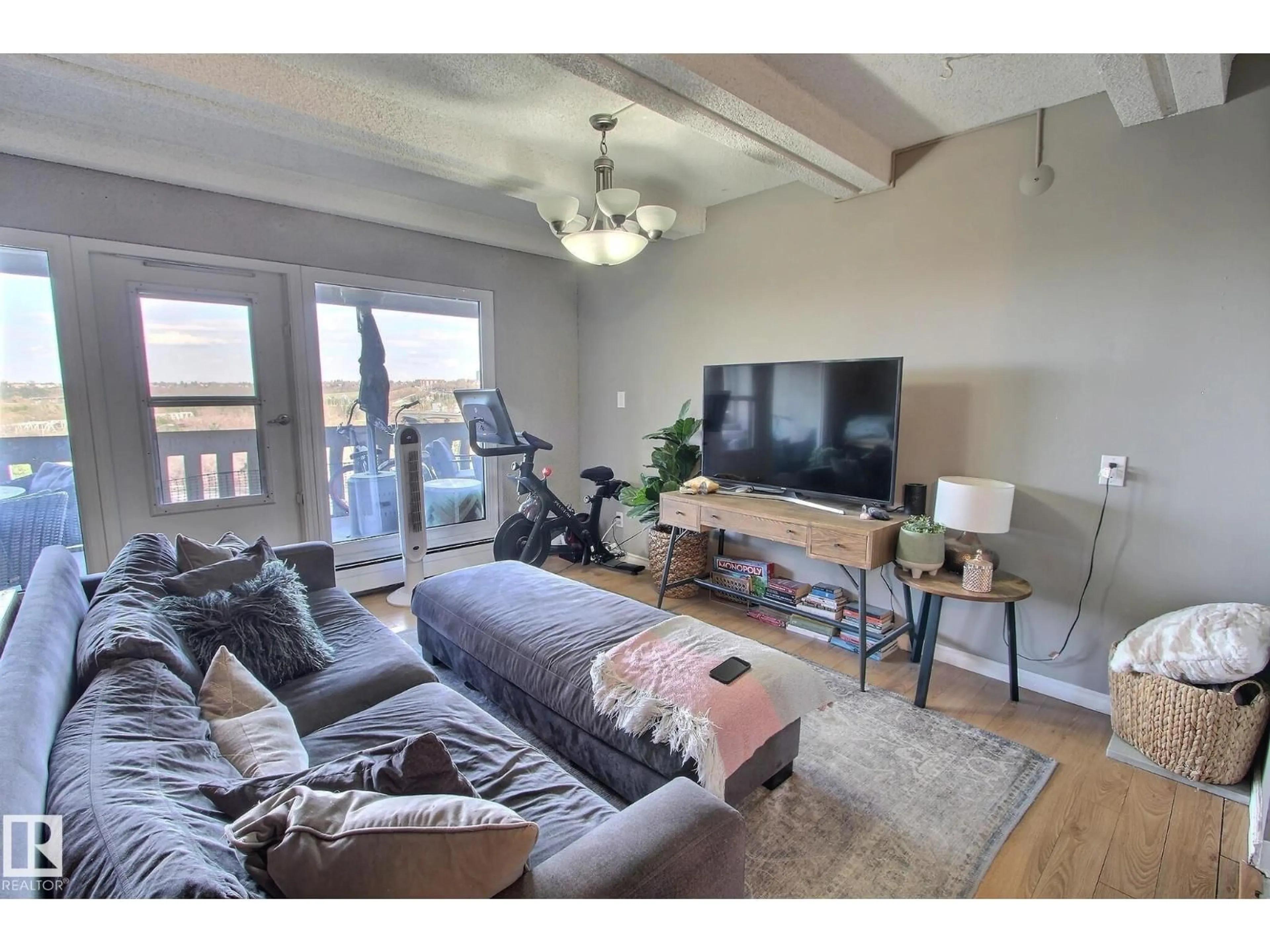 Living room with furniture, wood/laminate floor for 9918 - 508 101 ST, Edmonton Alberta T5K2L1