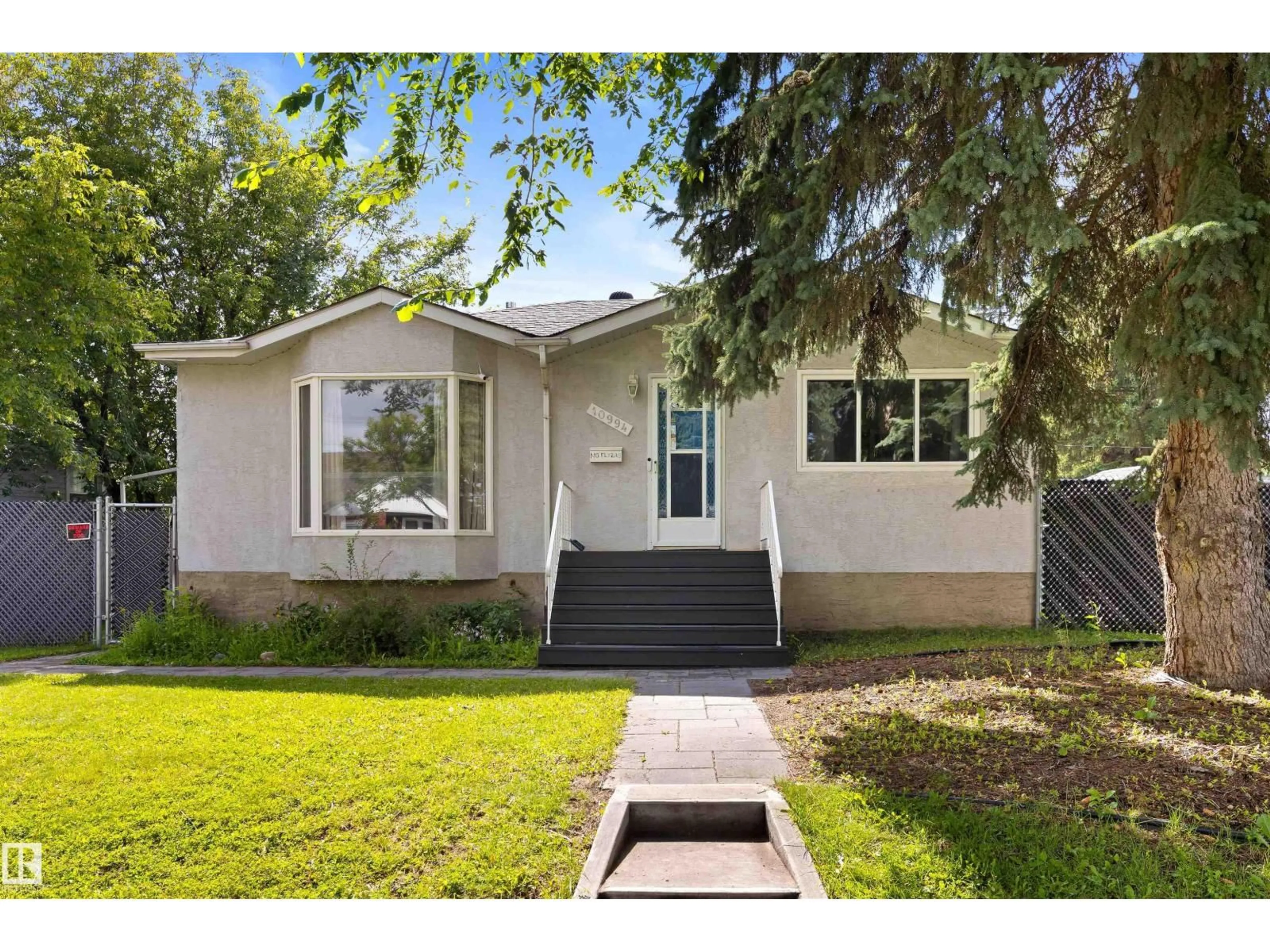 Home with vinyl exterior material, street for NW - 10994 135 ST, Edmonton Alberta T5M1K2