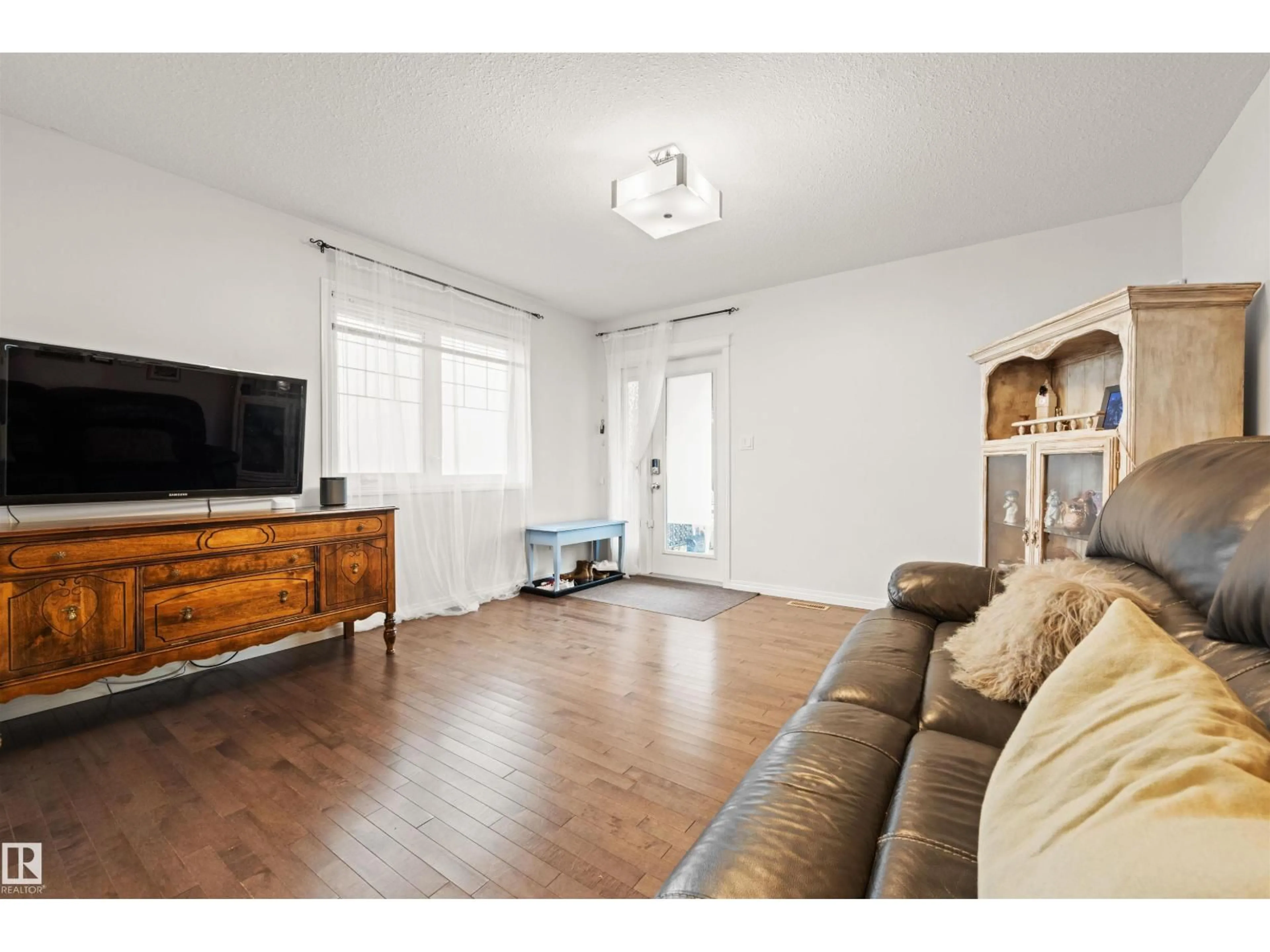 Living room with furniture, wood/laminate floor for 12425 111 AV, Edmonton Alberta T5M0M2