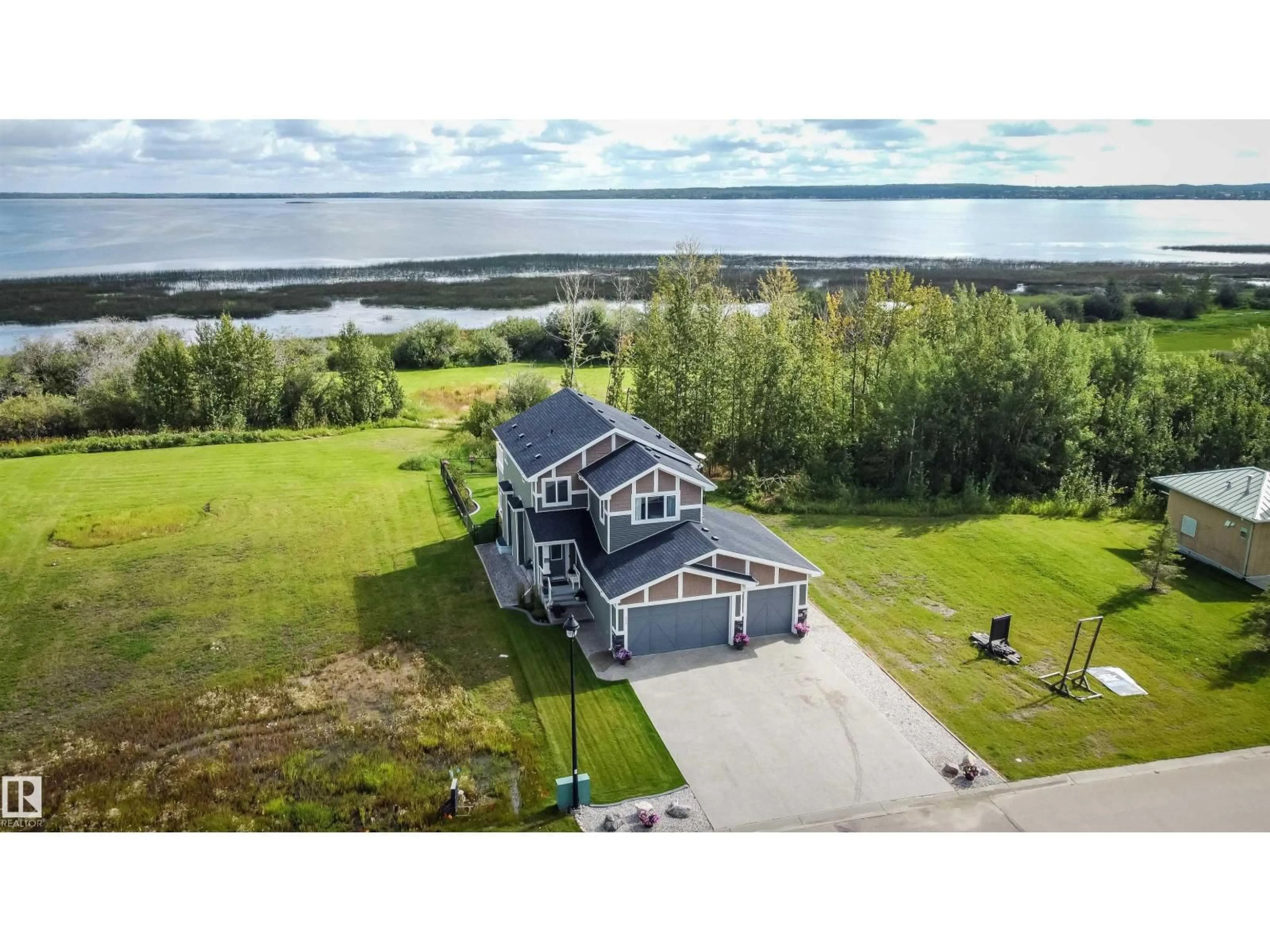 A pic from outside/outdoor area/front of a property/back of a property/a pic from drone, water/lake/river/ocean view for 3410 STE. ANNE TR, Rural Lac Ste. Anne County Alberta T0E0A1