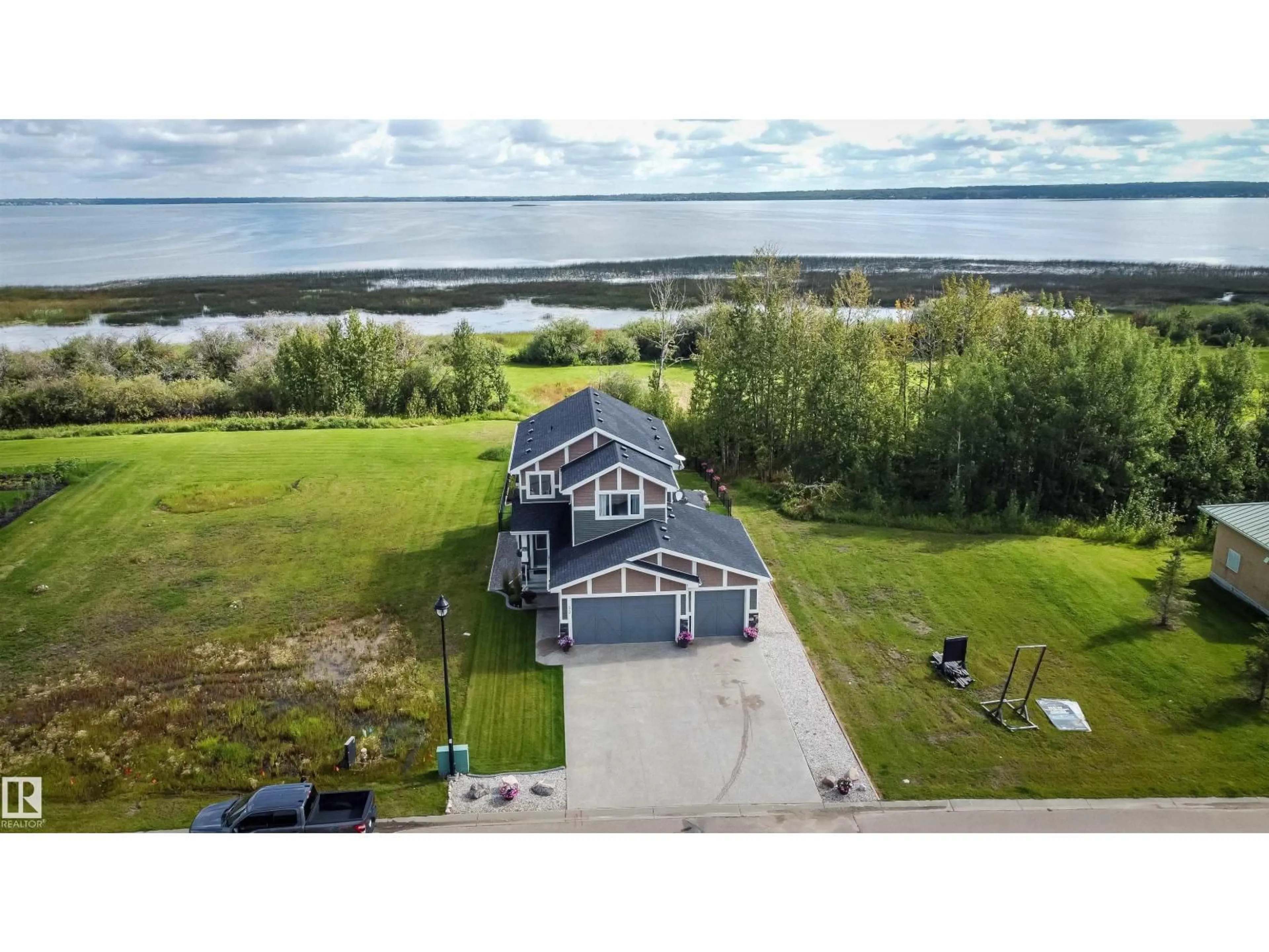 A pic from outside/outdoor area/front of a property/back of a property/a pic from drone, water/lake/river/ocean view for 3410 STE. ANNE TR, Rural Lac Ste. Anne County Alberta T0E0A1