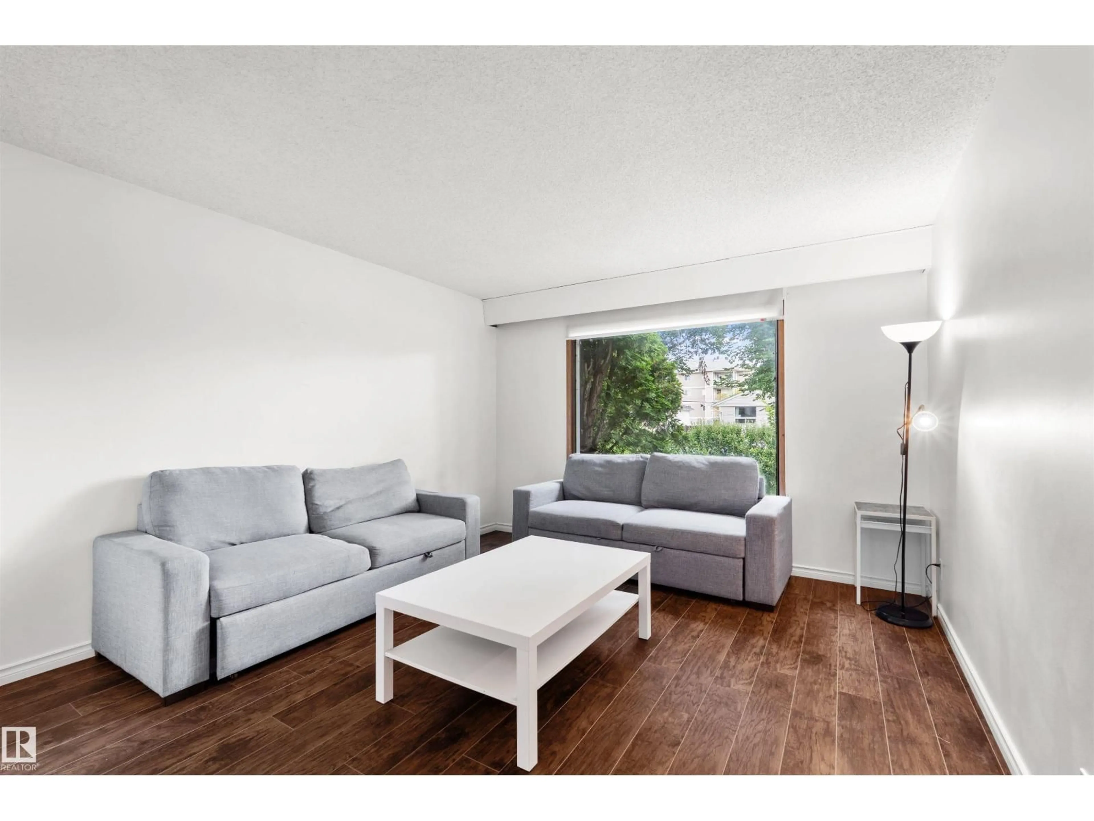 Living room with furniture, wood/laminate floor for 8723 81 AV, Edmonton Alberta T6C0W5