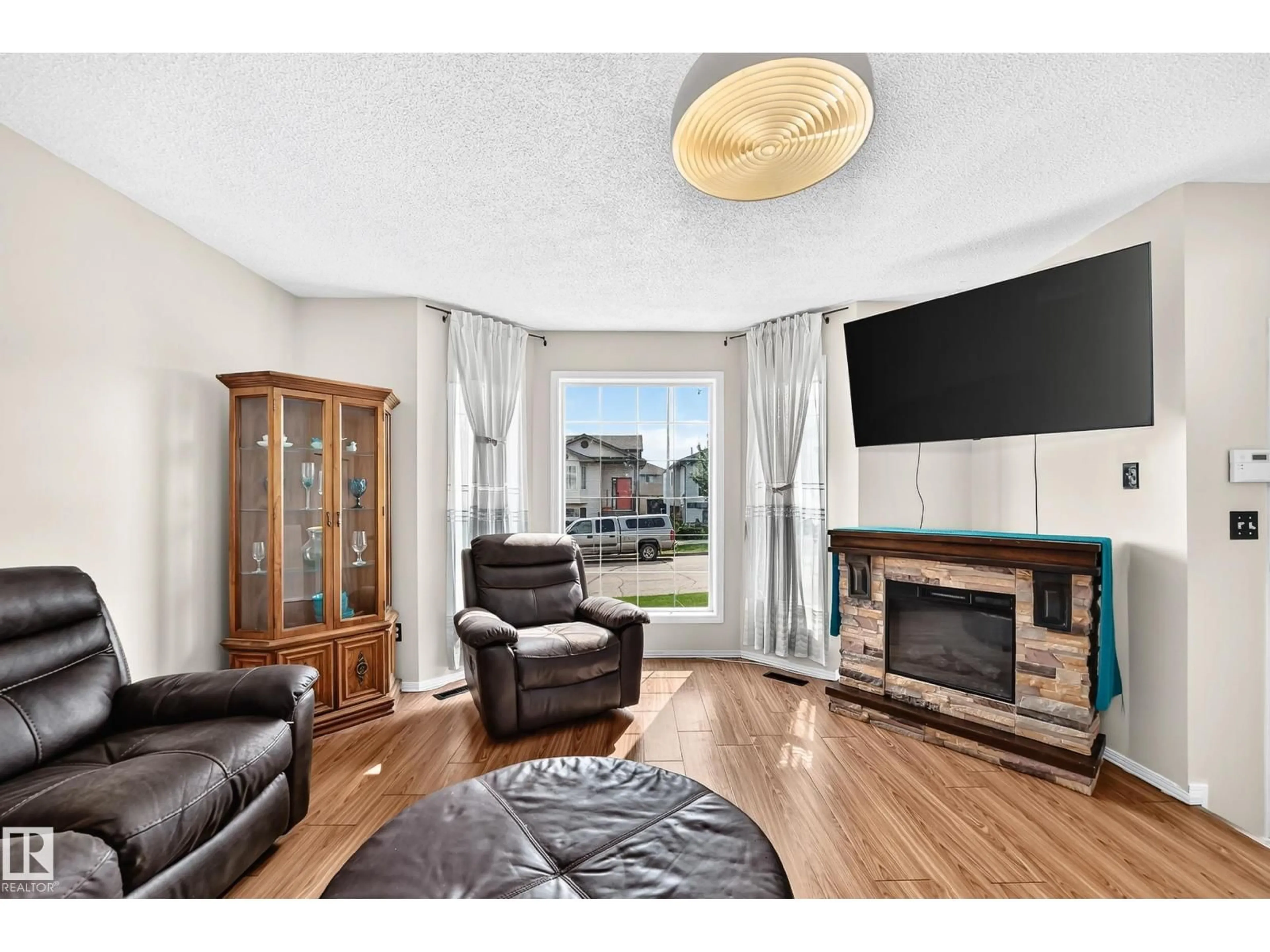 Living room with furniture, wood/laminate floor for 4520 149 AV, Edmonton Alberta T5Y2Z1