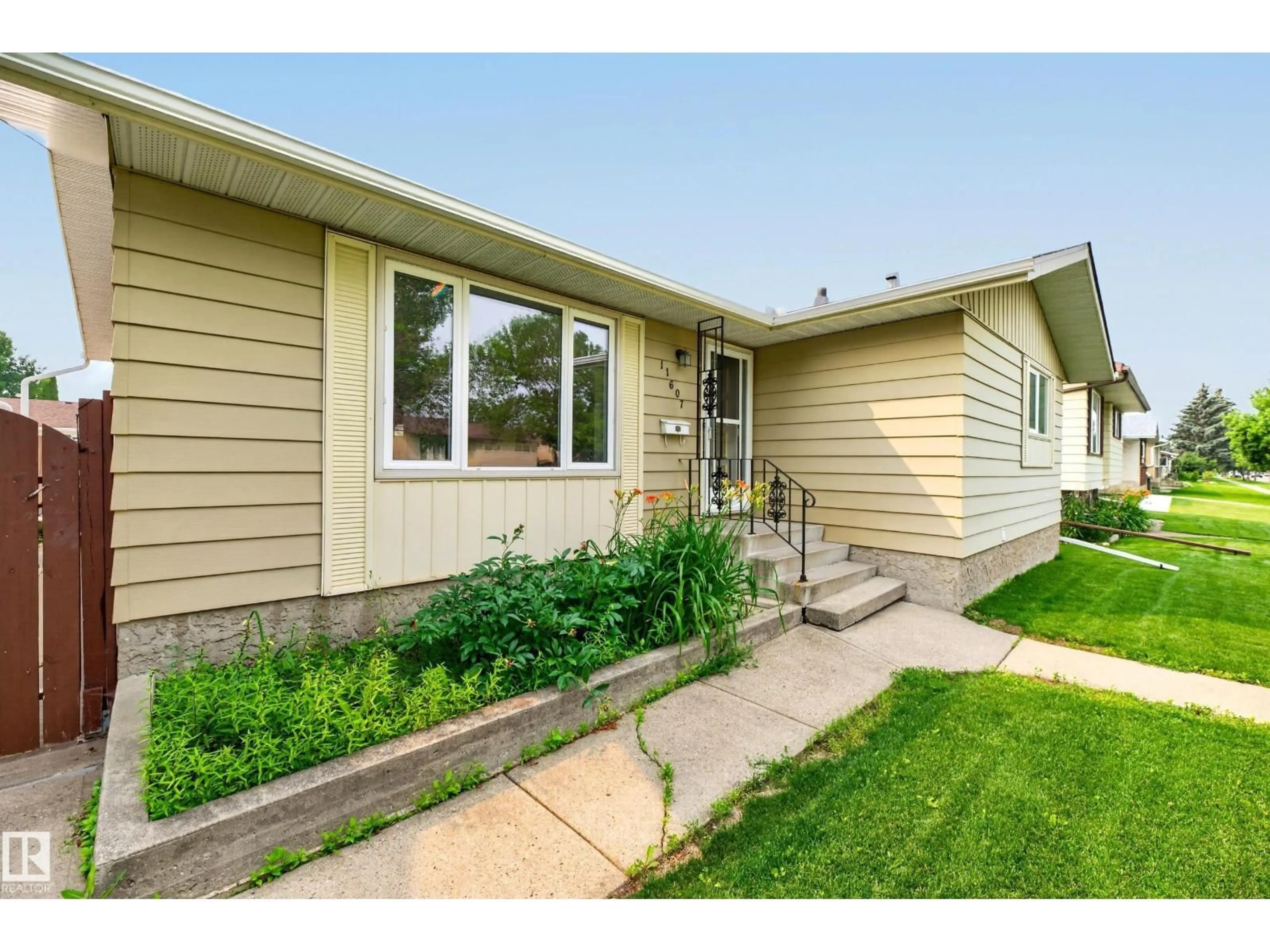 Home with vinyl exterior material, street for 11607 139 AV, Edmonton Alberta T5X3L3