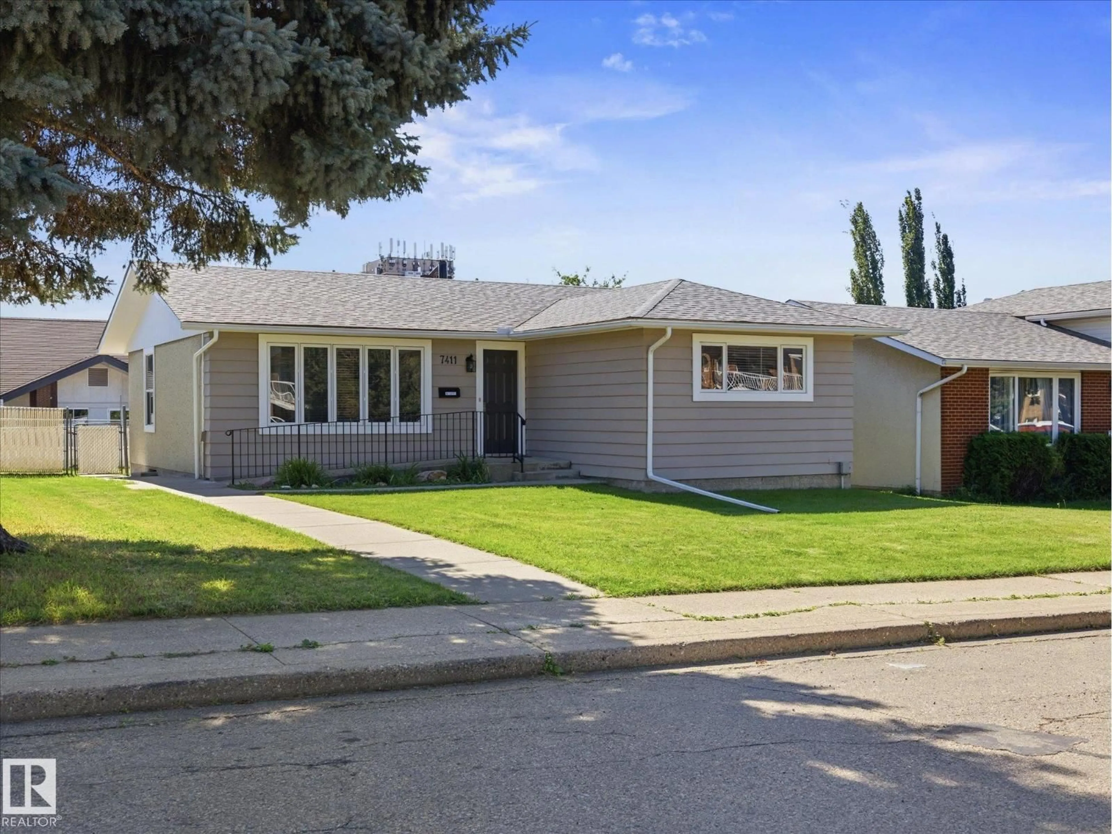Home with vinyl exterior material, street for 7411 141 AV, Edmonton Alberta T5C2N4