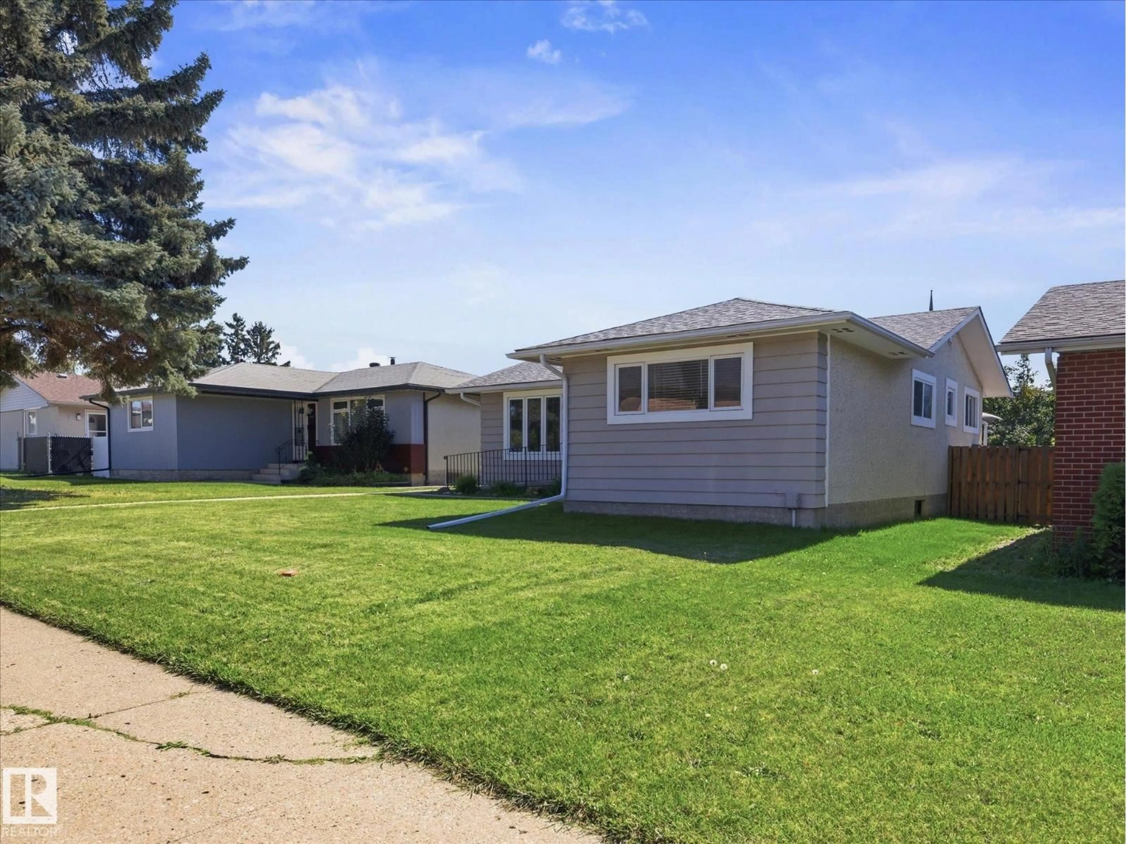 Home with vinyl exterior material, street for 7411 141 AV, Edmonton Alberta T5C2N4
