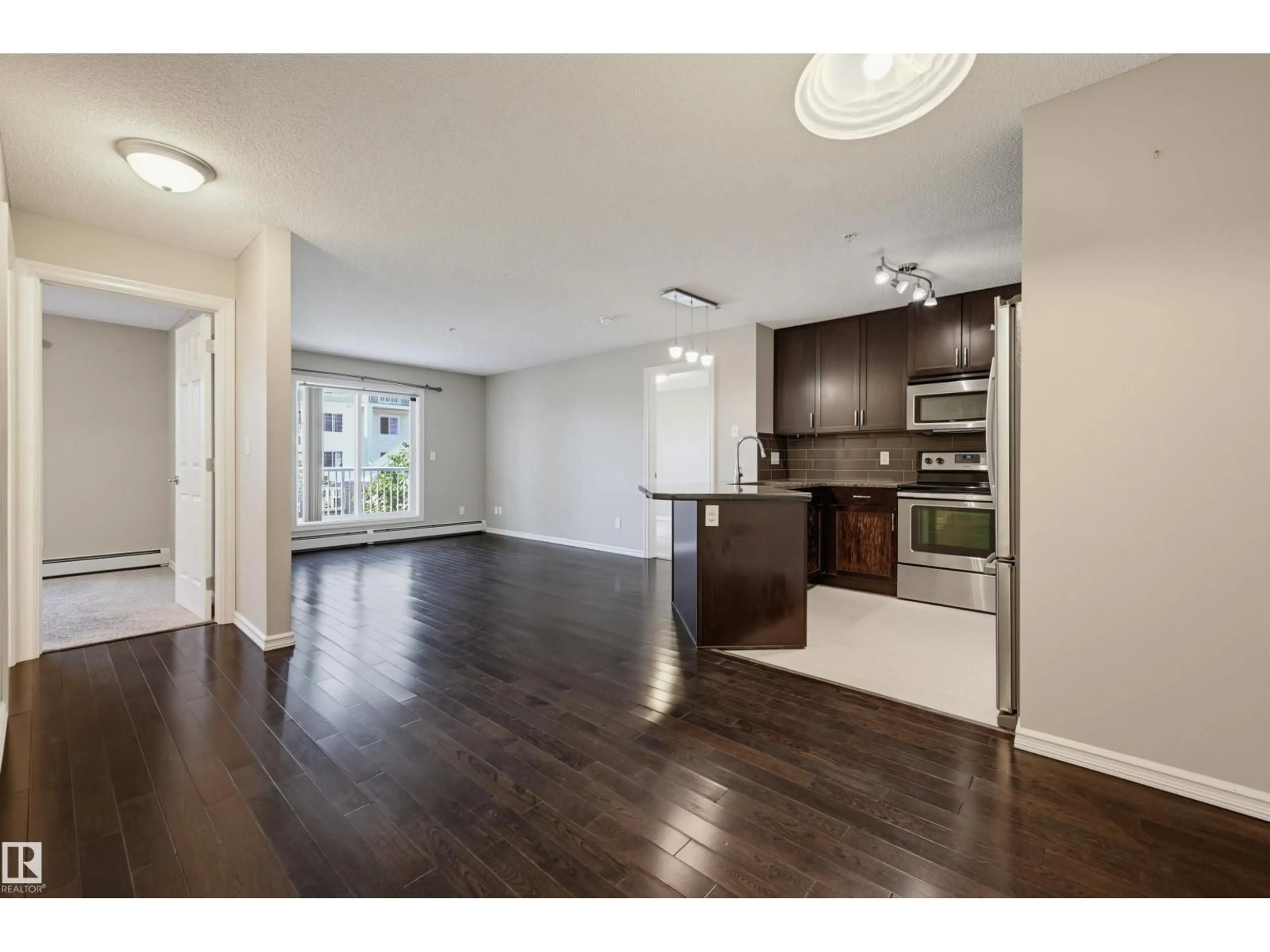 Open concept kitchen, wood/laminate floor for #208 - 2204 44 AV, Edmonton Alberta T6T0G5