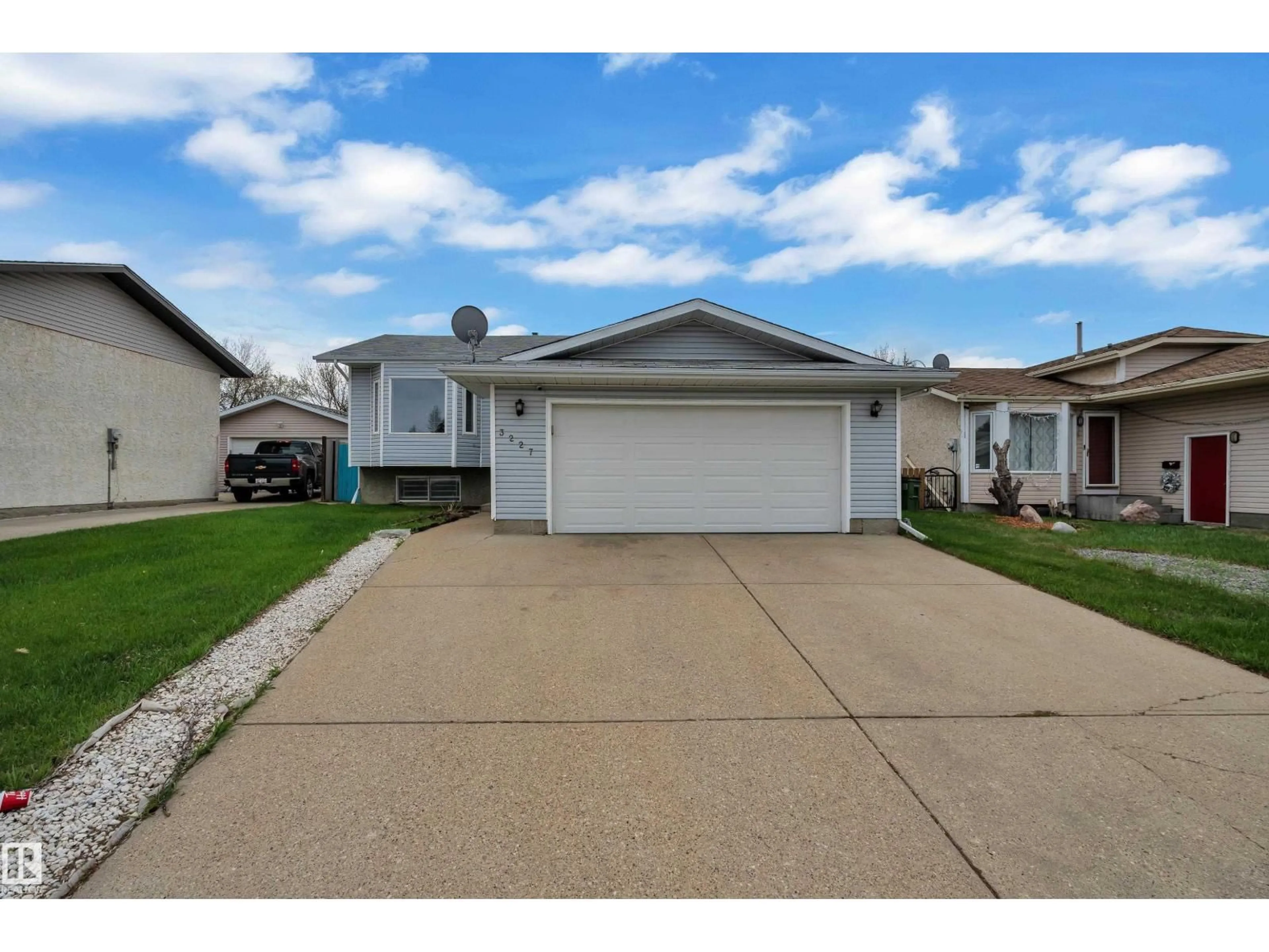Home with vinyl exterior material, street for NW - 3227 145 AV, Edmonton Alberta T5Y2E9